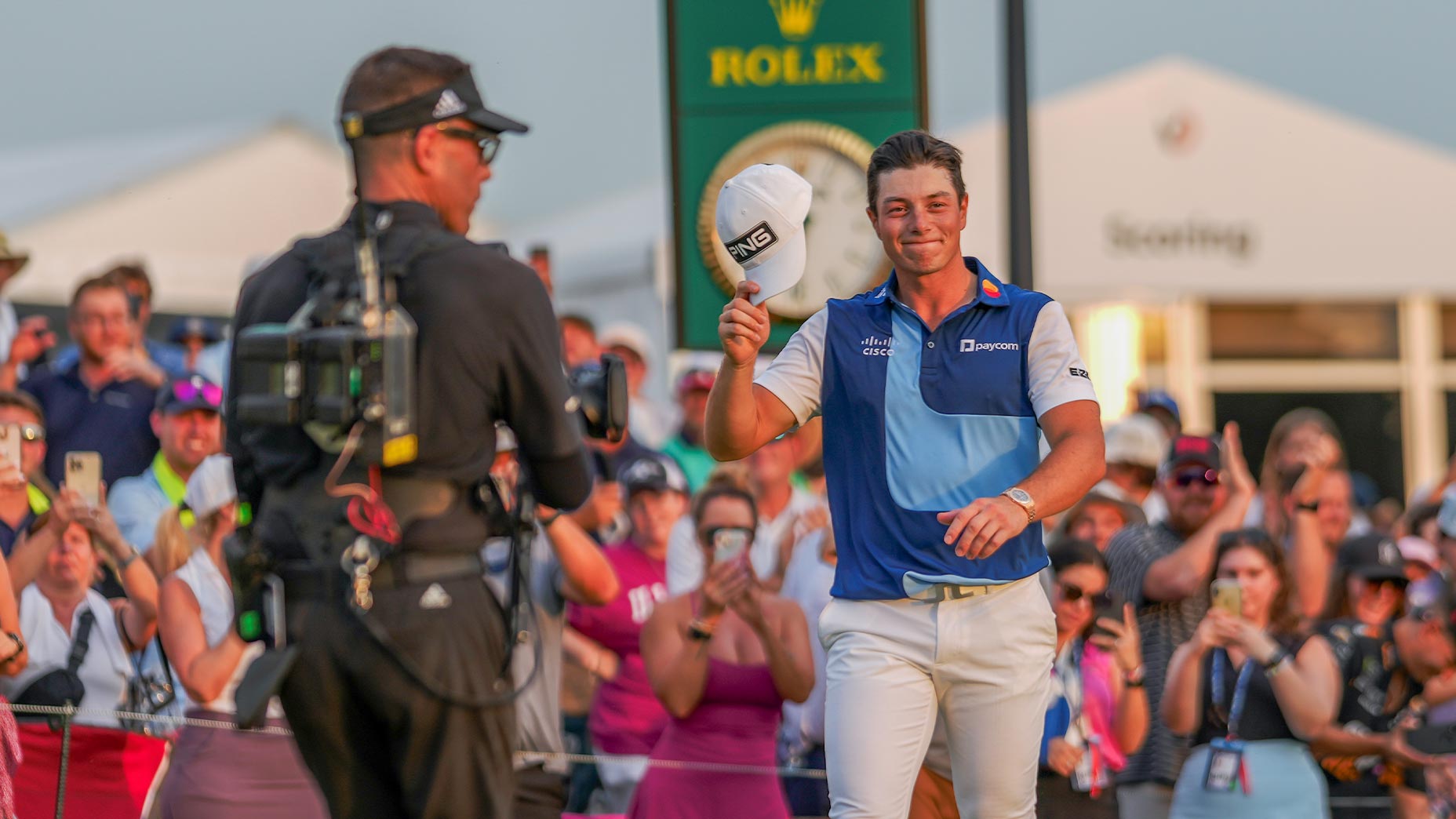 viktor hovland tips cap to crowd at tour championship while a photographer takes photo