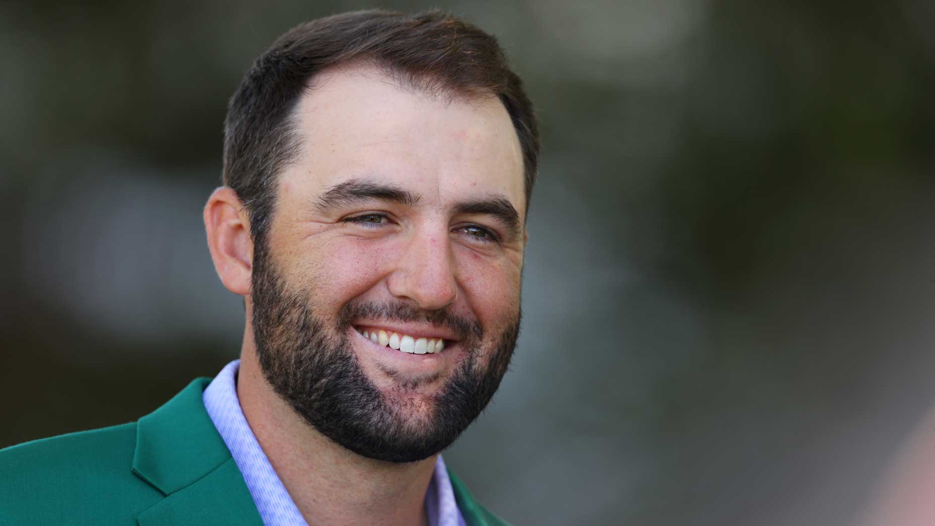 Scottie Scheffler smiles in his green jacket.