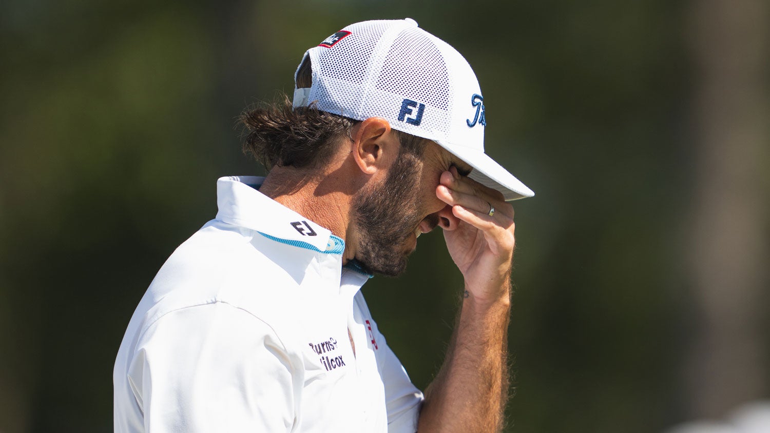 Max Homa clears sand from his eyes during the 2024 Masters.