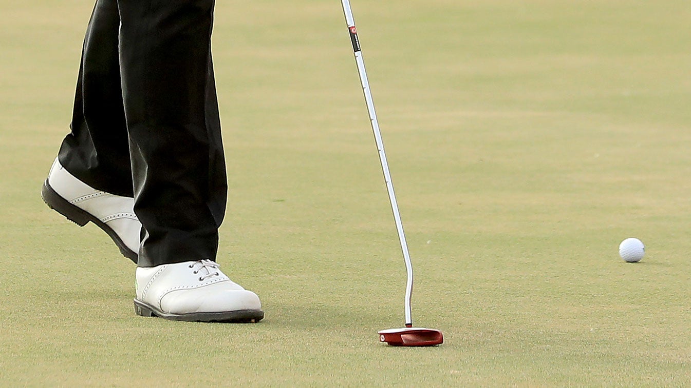 hane Lowry of Ireland taps down a spike mark before hitting a crucial par putt on the par 4, 17th hole during the final round of the Abu Dhabi HSBC Golf Championship at the Abu Dhabi Golf Club