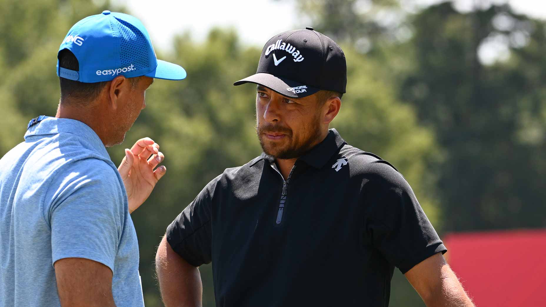Xander Schauffele talks with coach at East Lake ahead of 2024 Tour Championship.