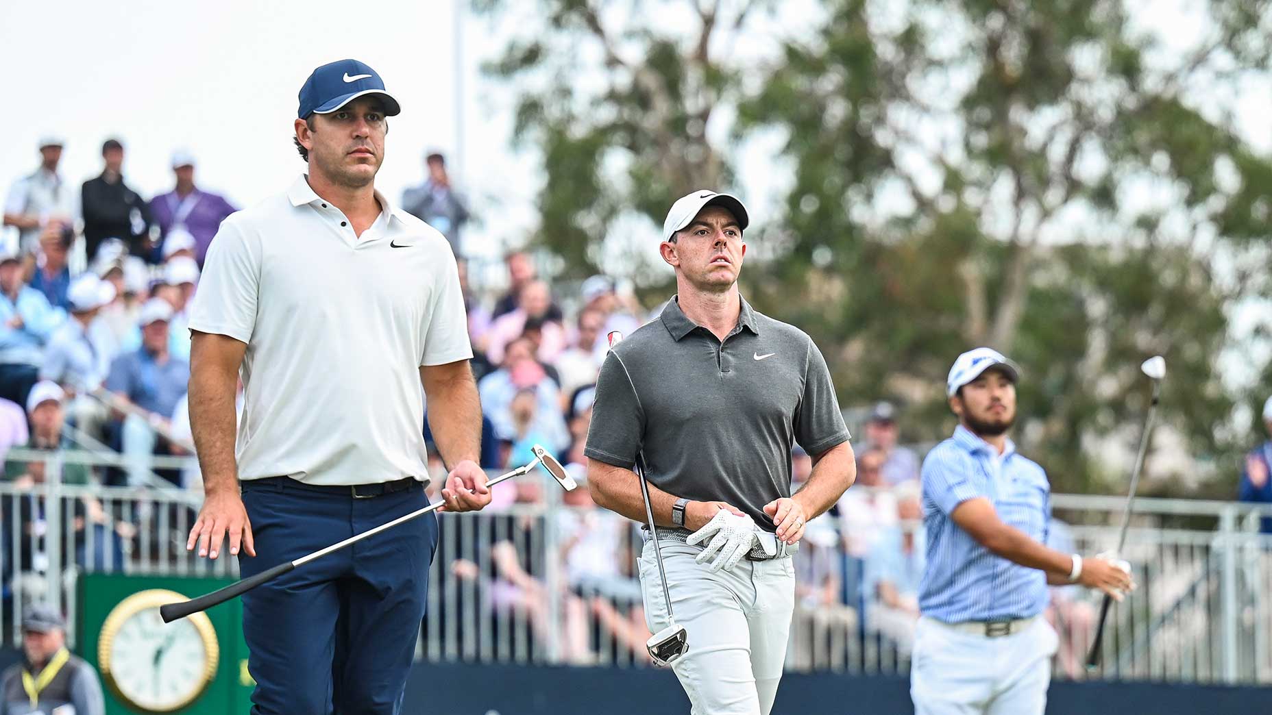 rory mcilroy and brooks koepka walk down the range at the u.s. open in shirts and hats