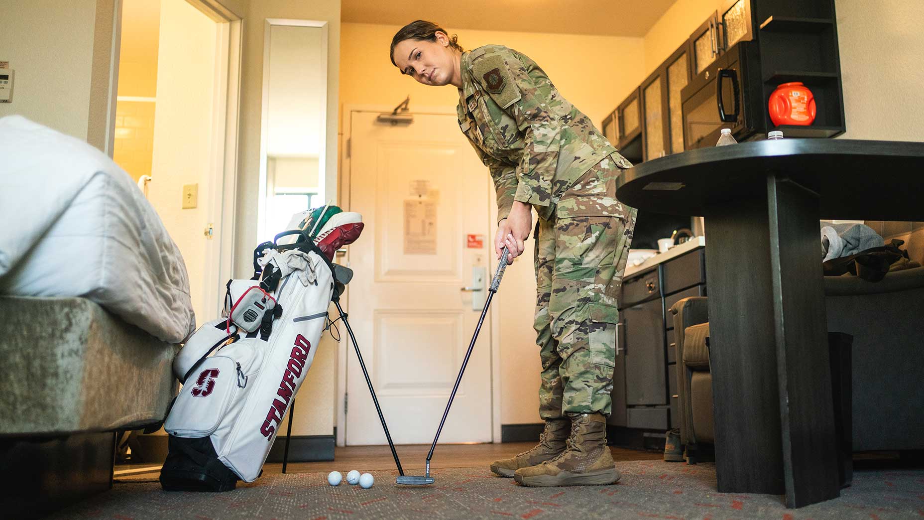 rachel heck rolls putts in her hotel room.