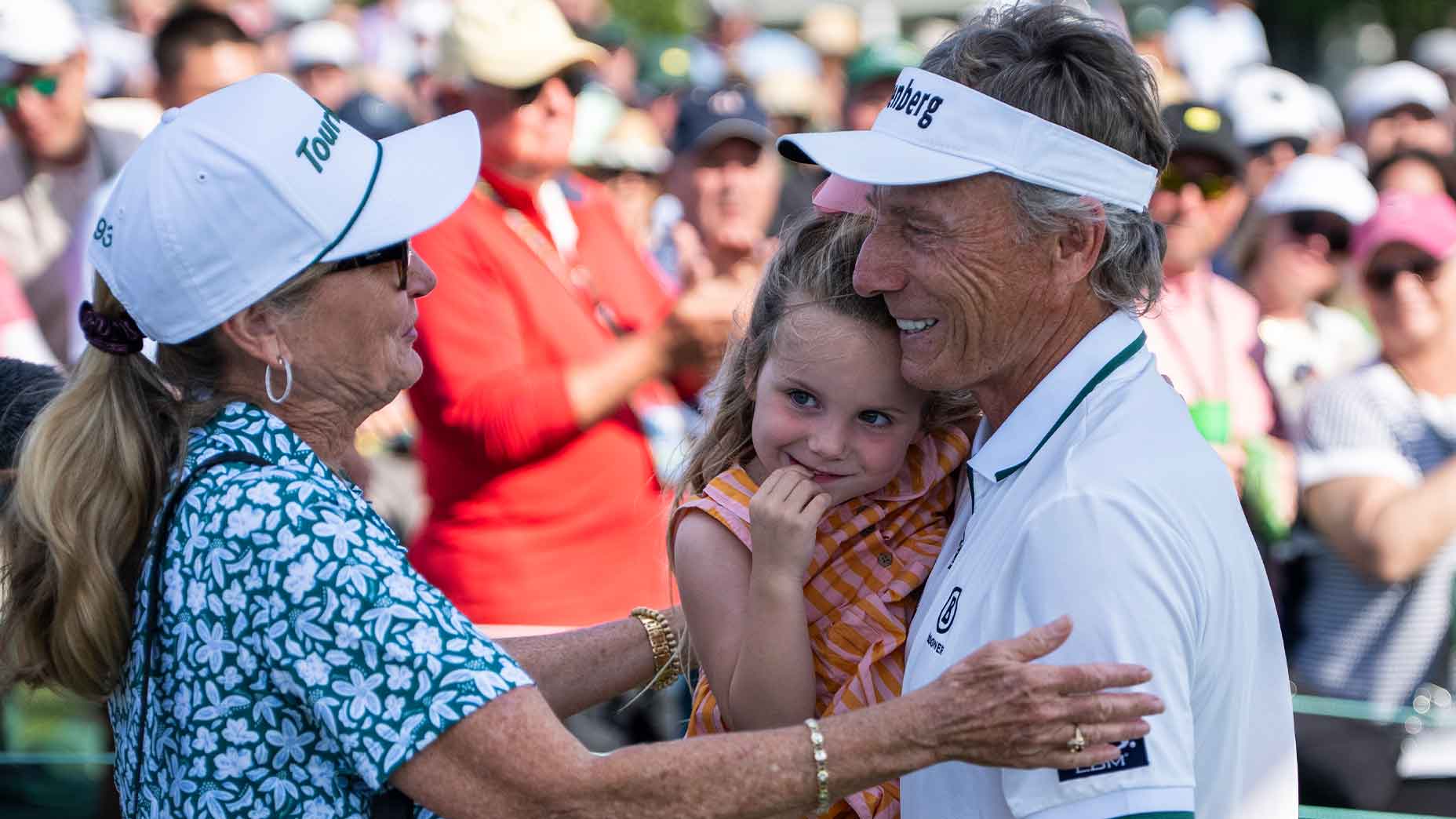 Bernahrd Langer holds his granddaughter and wife on the 18th hole at Augusta National.