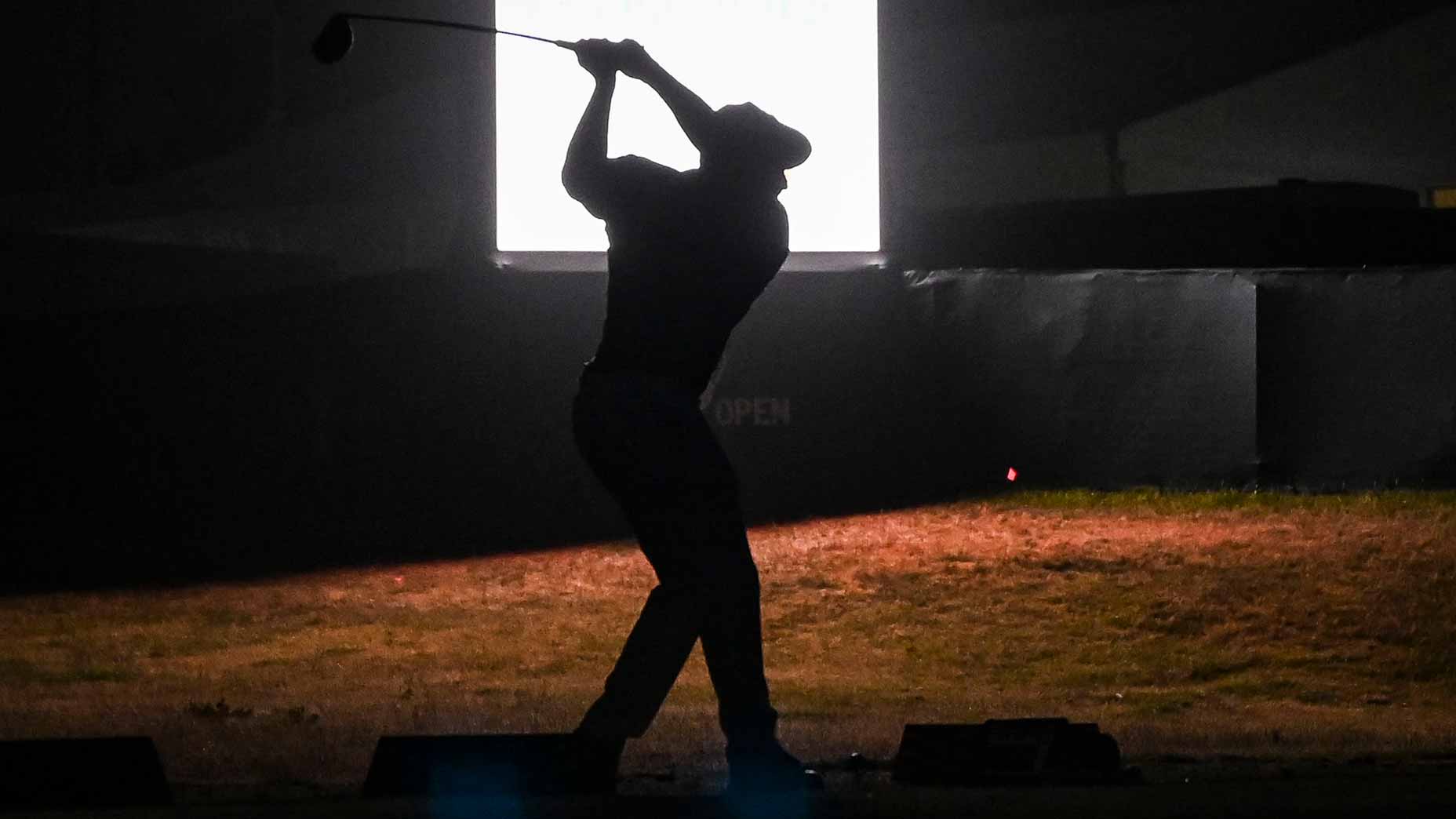 Bryson DeChambeau, who is hunting for a 2025 Masters win, is silhouetted as he hits balls at night on the practice range after play following the first round of the 121st U.S. Open on the South Course at Torrey Pines Golf Course.