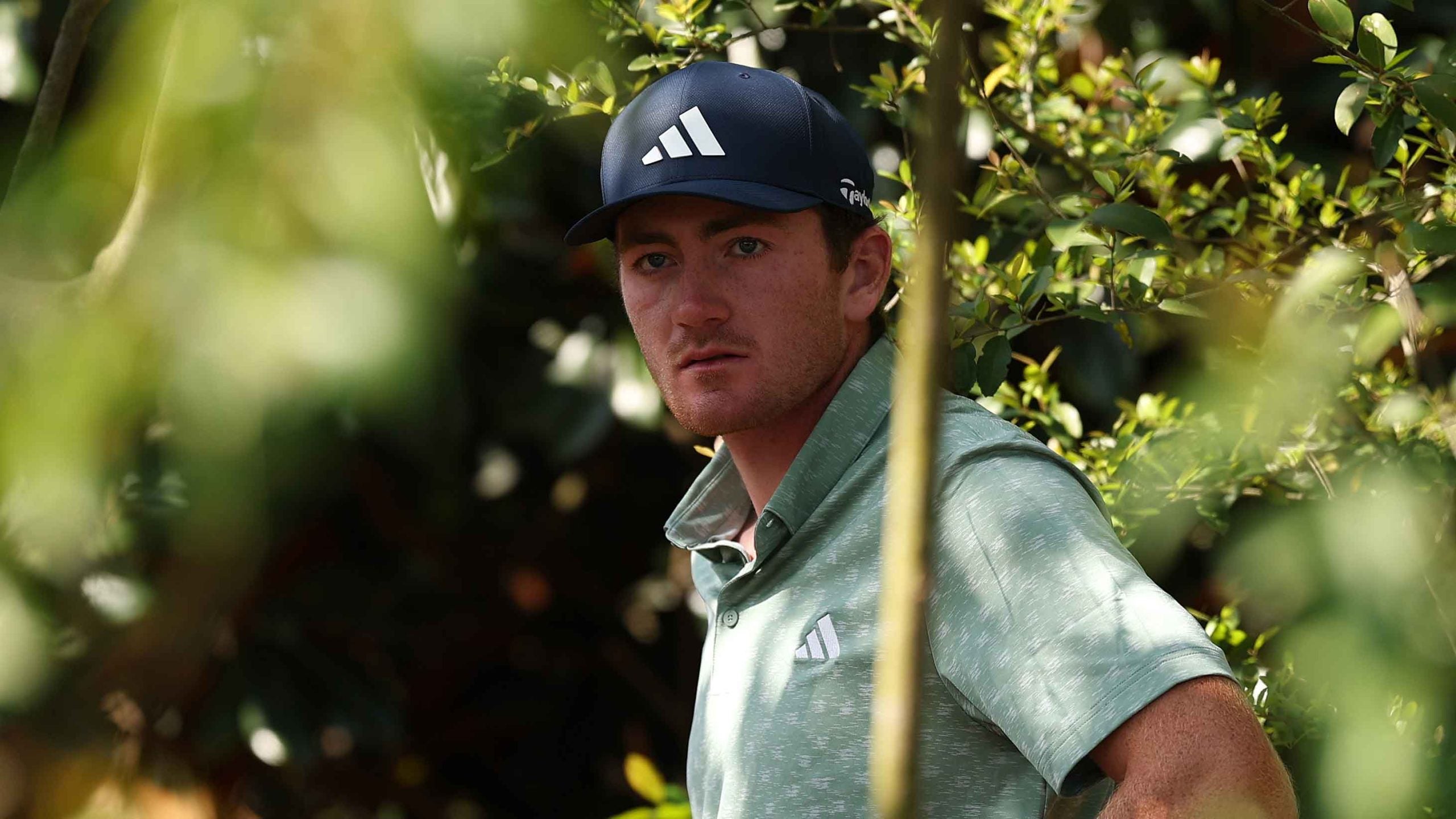 Nick Dunlap of the United States prepares to play a shot from the trees on the fifth hole during the first round of the 2025 Masters Tournament at Augusta National Golf Clu