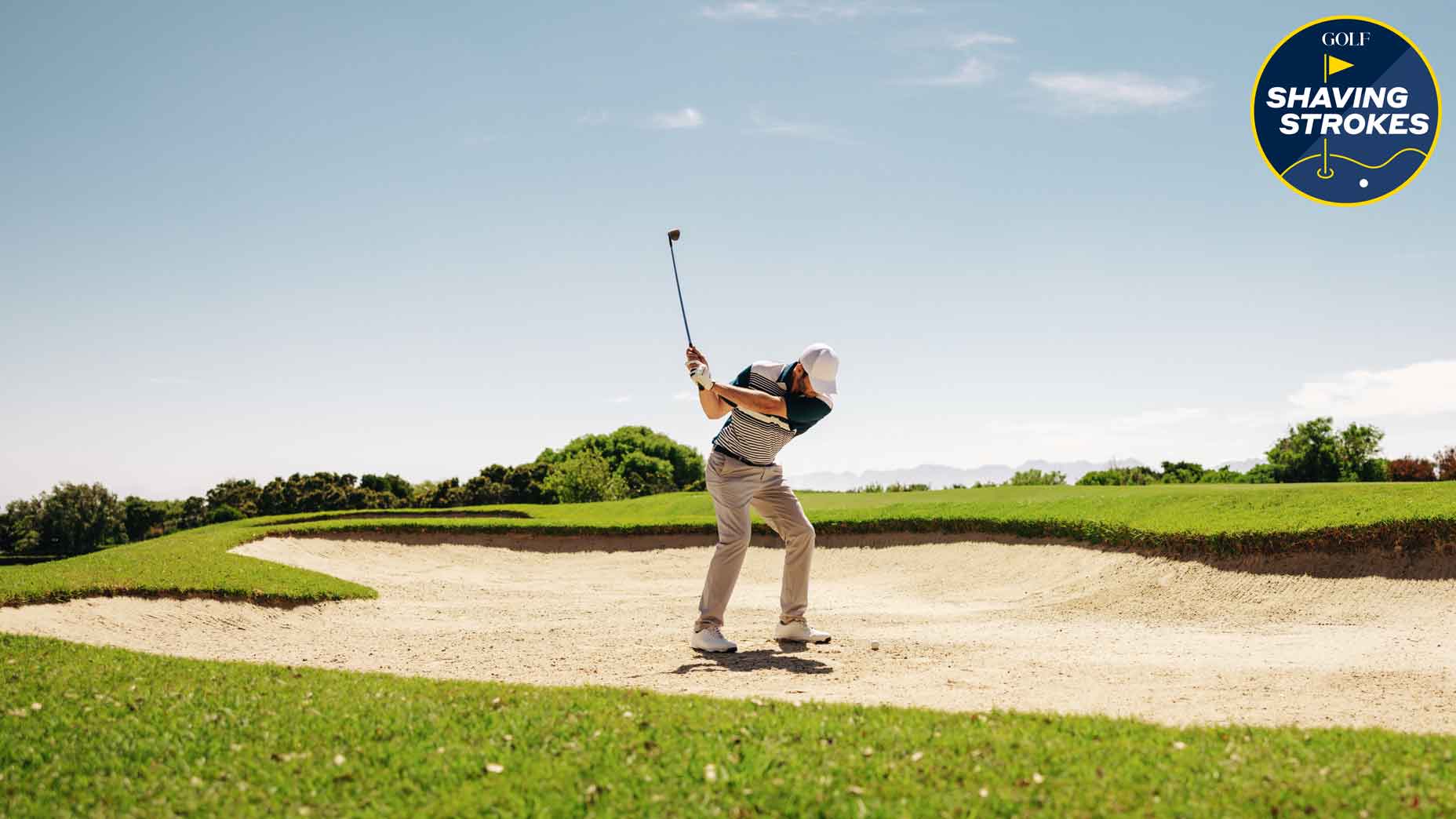 golfer hits shot out of fairway bunker