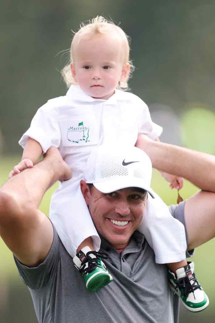 Brooks Koepka of the United States smiles with his son, Crew Sims Koepka, on the fifth hole during the Par Three Contest prior to the 2025 Masters Tournament at Augusta National Golf Club on April 09, 2025 in Augusta, Georgia.