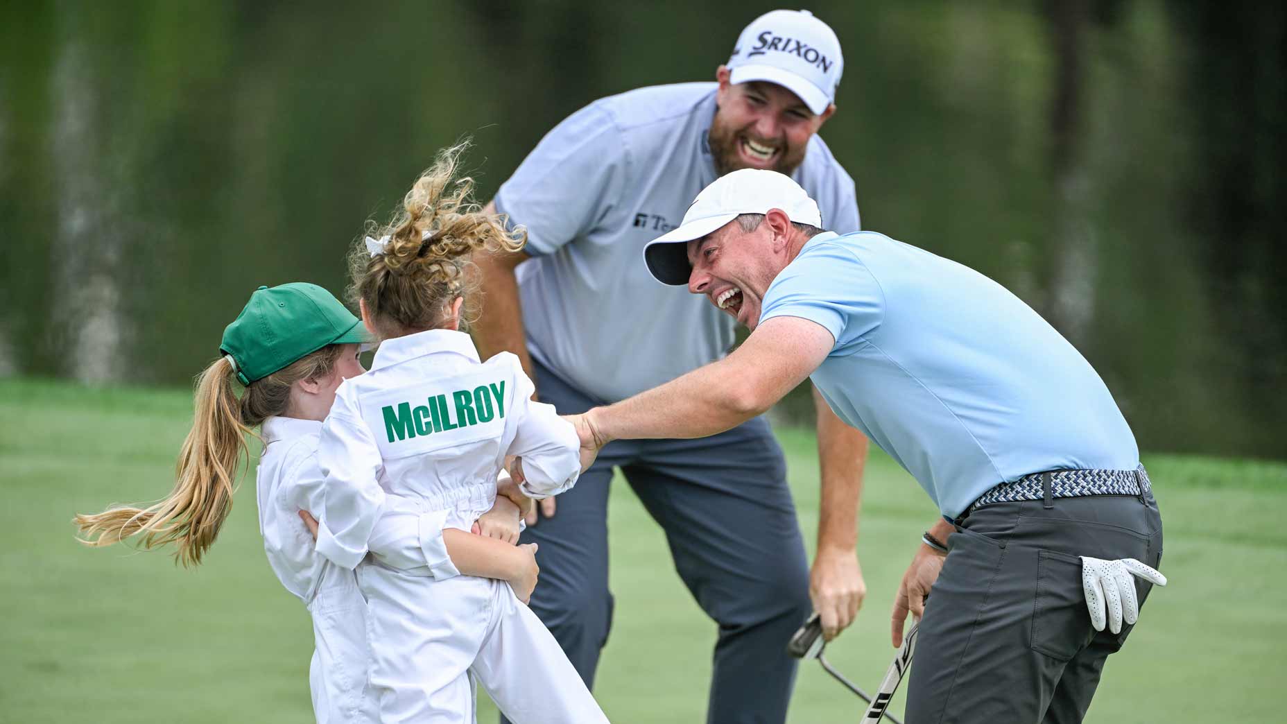 Shane Lowry, Rory McIlroy and Tommy Fleetwood of England react to Poppy McIlroy's made putt during the Masters Par 3 Contest prior to the 2025 Masters at Augusta National.