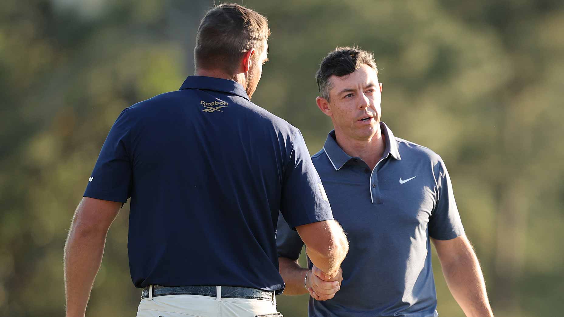 Rory McIlroy shakes hands with Bryson DeChambeau during the final round of the 2025 Masters. They didn't talk to each other all day.