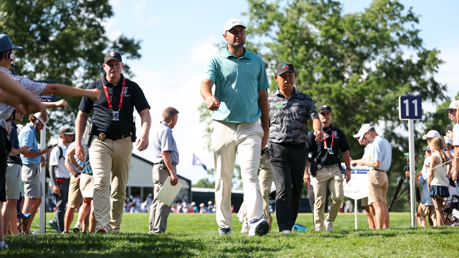 Scottie Scheffler and Si Woo Kim walk by spectators on his way towards the 12th hole tee box during the third round of the PGA Championship at Quail Hollow Club on Saturday, May 17, 2025 in Charlotte, North Carolina.