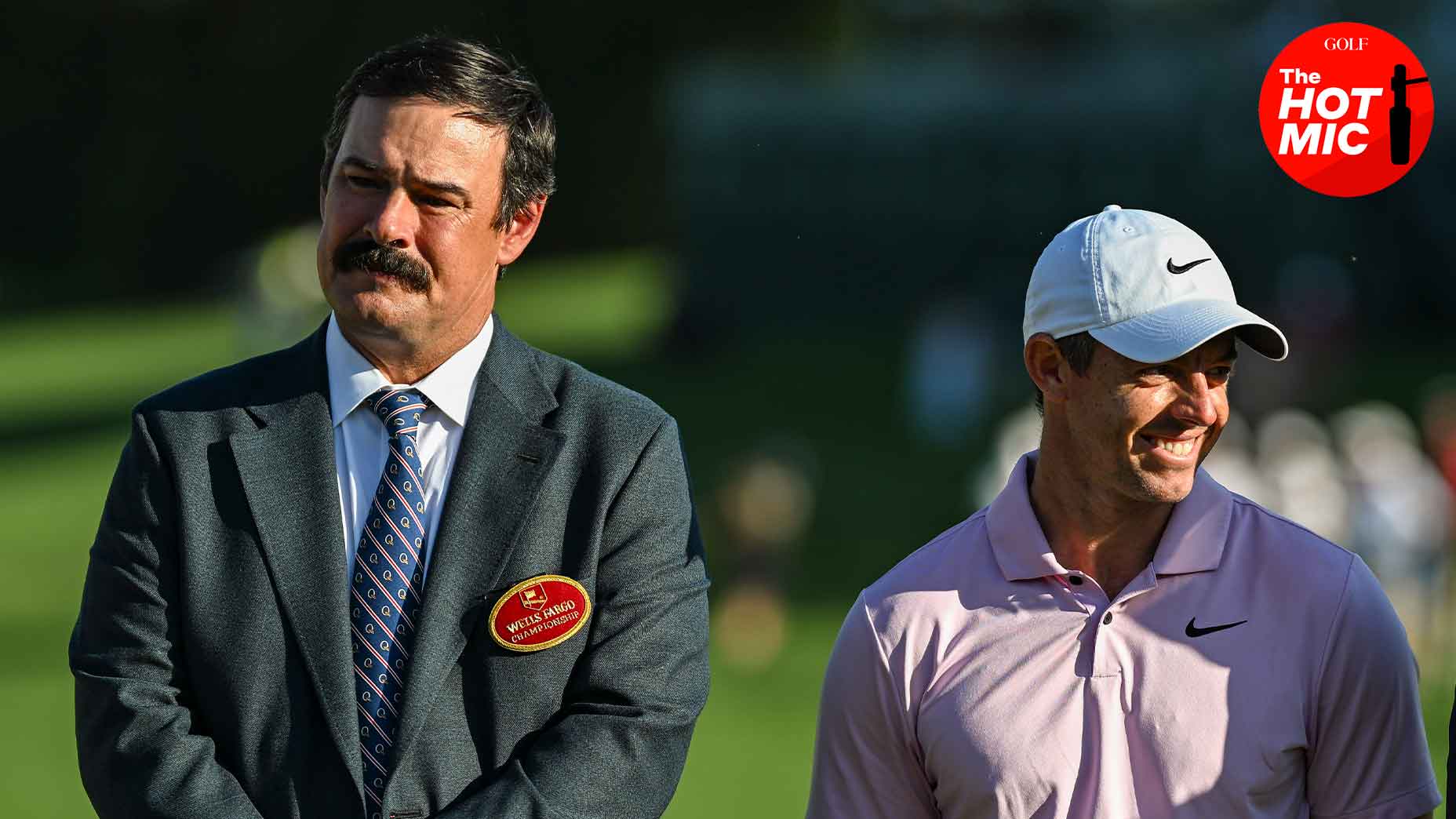 johnson wagner and rory mcilroy smile at a golf tournament in suit and white hat
