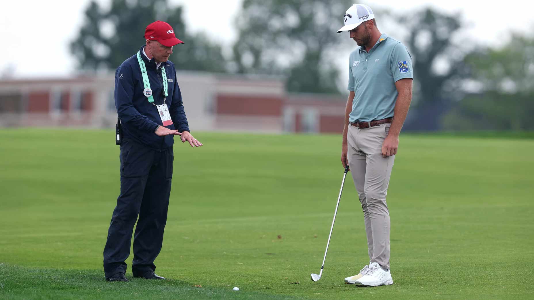 Sam Burns talks with a rules official at Oakmont.