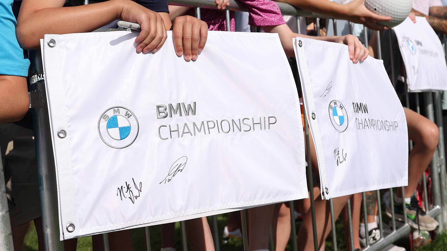 Fans hold up BMW Championship flags at the 2024 tournament.