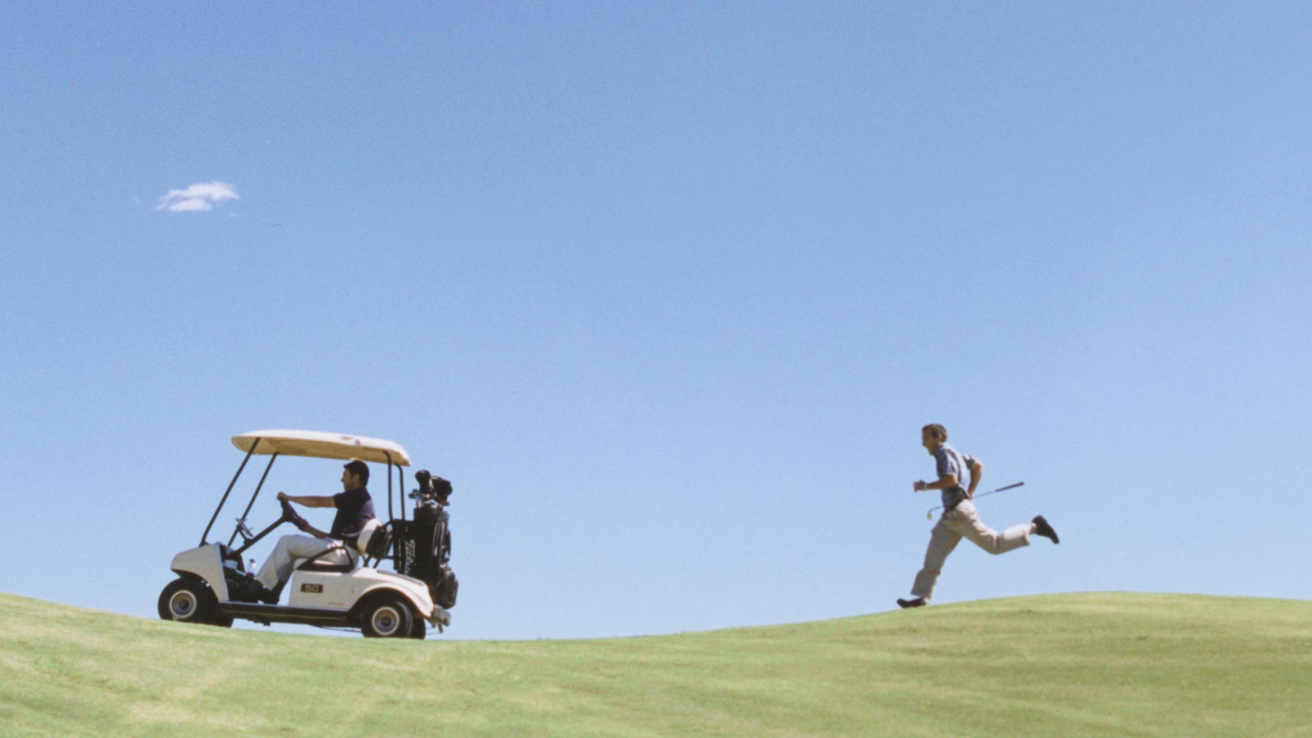 golfer chasing golf cart on golf course