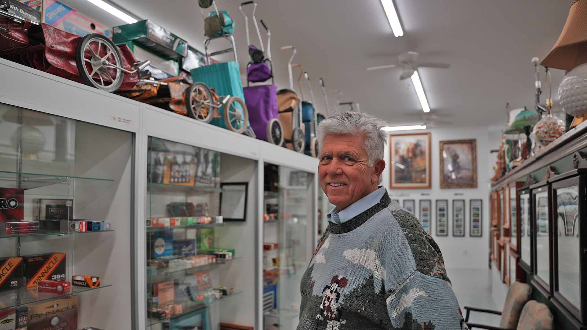 Robert Zokoe in front of display cases at his American Golf Museum.