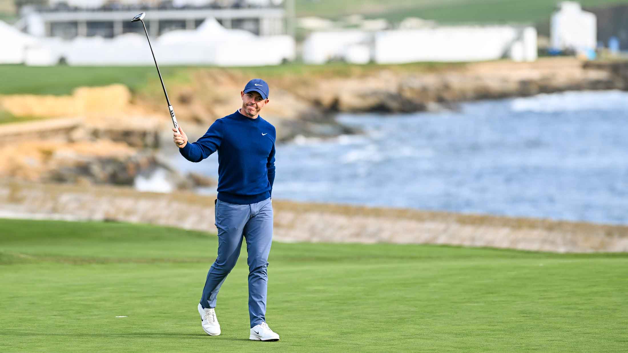 Rory McIlroy of Northern Ireland raises his putter to fans as he celebrates his two stroke victory on the 18th hole green during the final round of the AT&T Pebble Beach Pro-Am