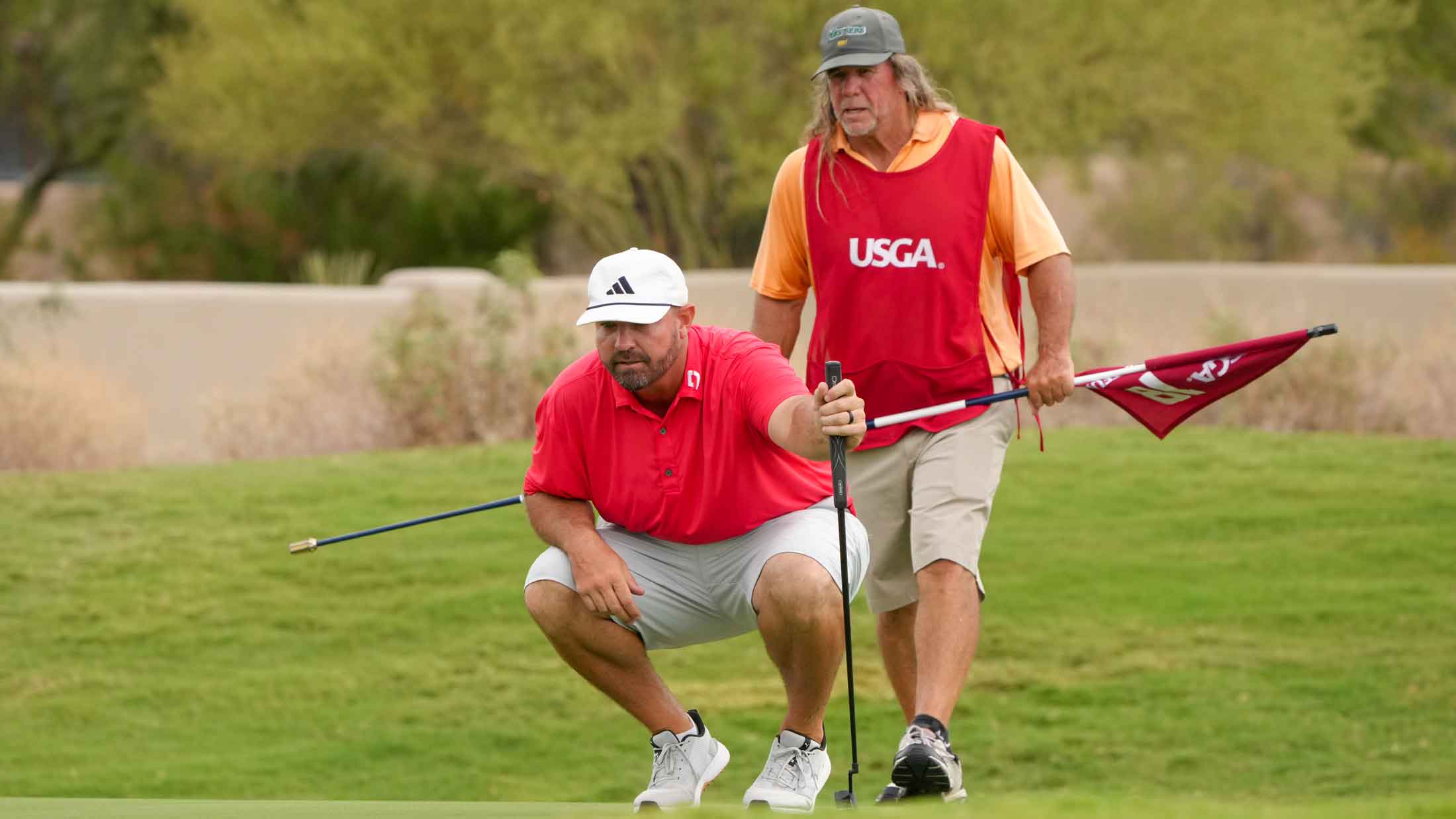 Brandon Holtz and his caddie and father Jeff Holtz line up their putt at the 18th hole during the final round of the 2025 U.S. Mid-Amateur at Troon Country Club in Scottsdale, Ariz.