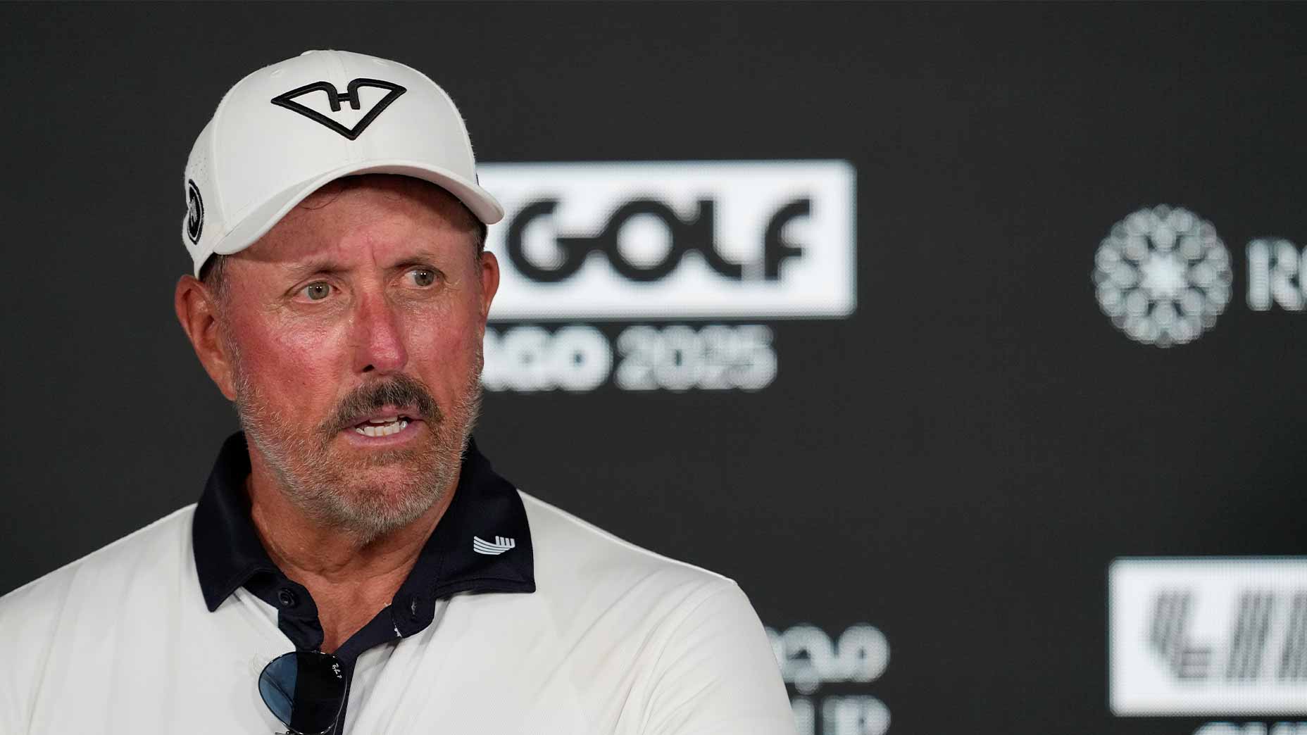 phil mickelson speaks at a liv golf press conference in white hyflyers hat and white shirt