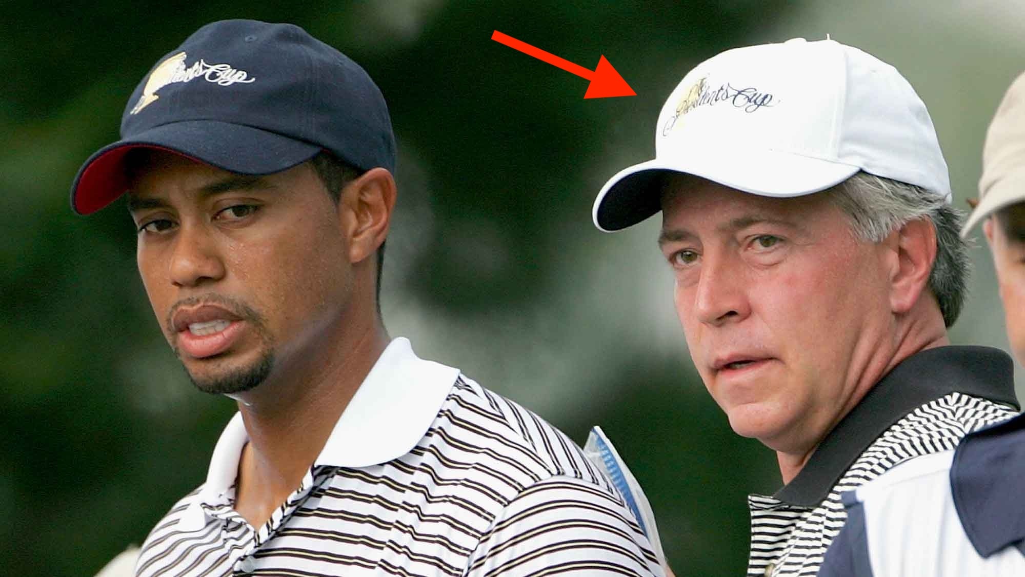 chiropractor Tom LaFountain holds an ice pack to the back of Tiger Woods of the United States team as caddie Billy Foster looks on during Friday Four-Ball matches at the 2005 Presidents Cup