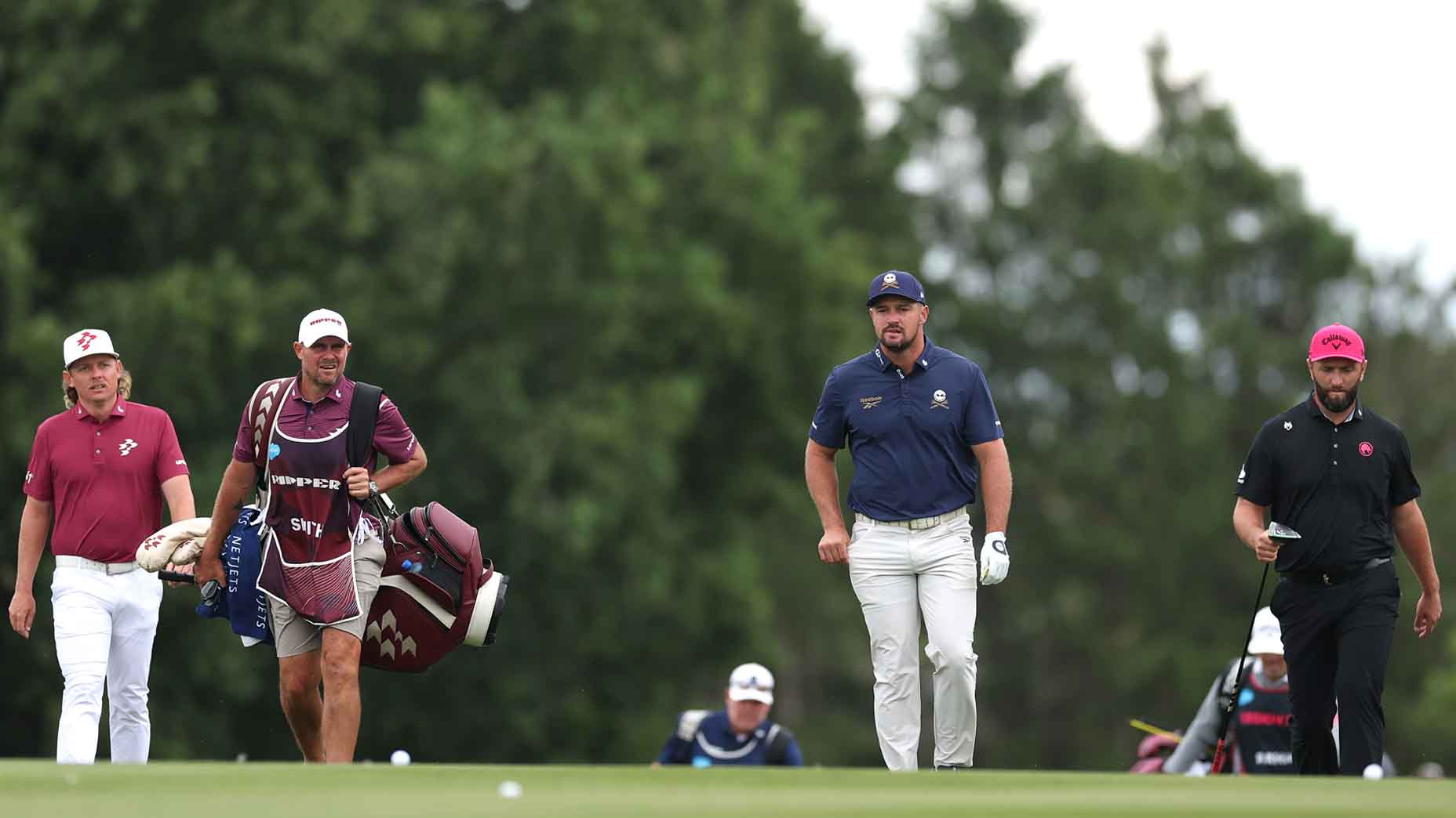 Bryson DeChambeau, Jon Rahm and Cam Smith walk the fairway at LIV UK