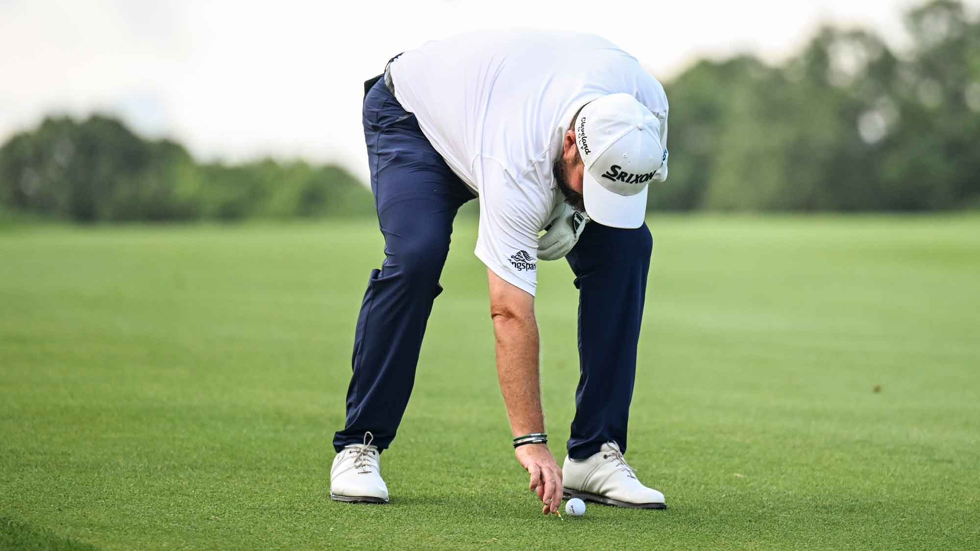 Shane Lowry of Ireland places his ball back down with preferred lies in effect on the 14th hole after heavy rainfall during the third round of the Travelers Championship at TPC River Highlands on June 22, 2024, in Cromwell, Connecticut. (