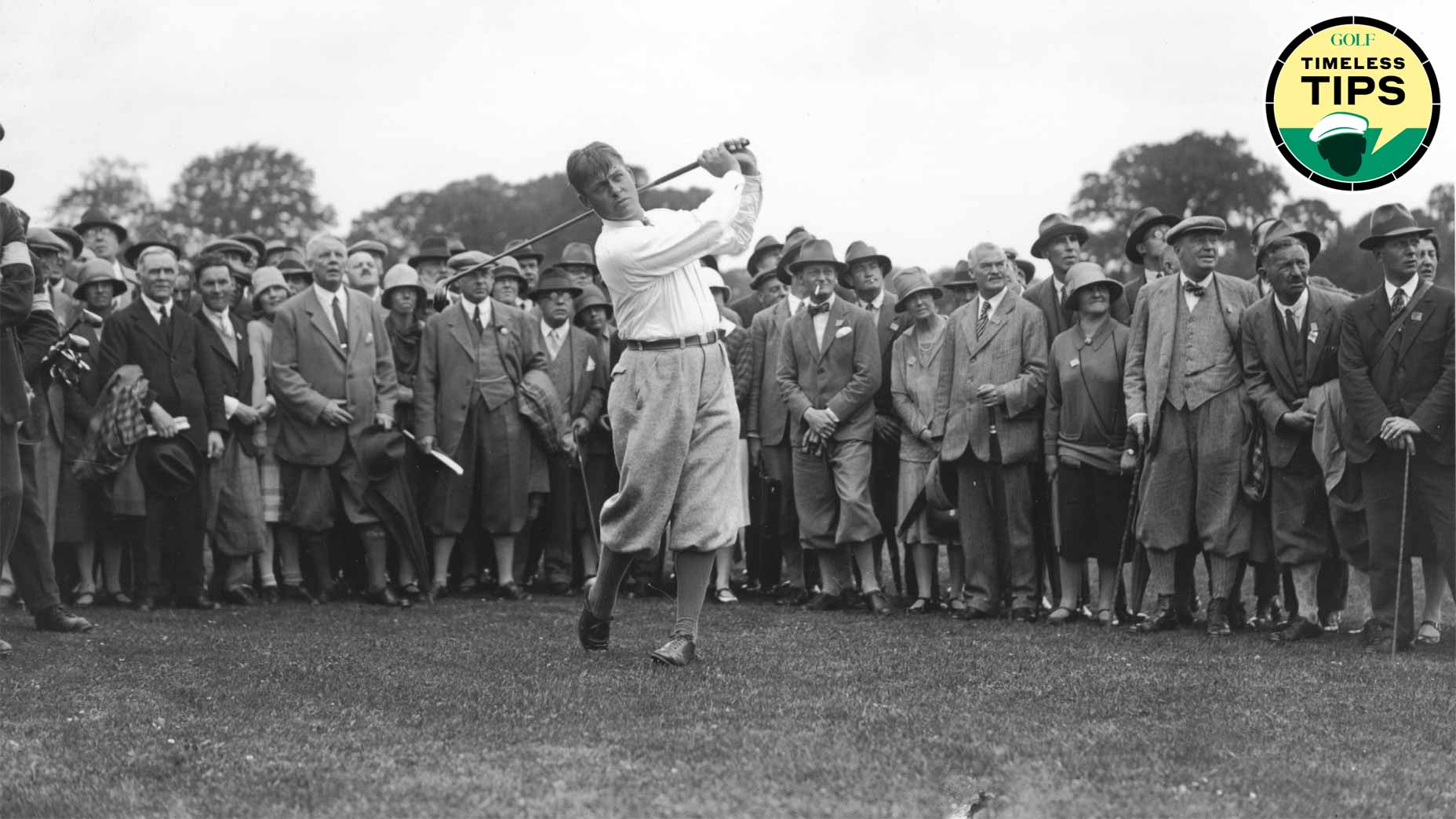 bobby jones swings golf club while crowd watches