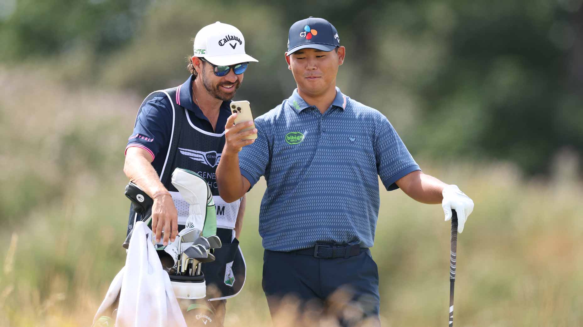 Si Woo Kim of South Korea and caddie Manny Villegas share a joke on day one of the Genesis Scottish Open 2025 at The Renaissance Club on July 10, 2025 in North Berwick, Scotland. (Photo by Warren Little/Getty Images)