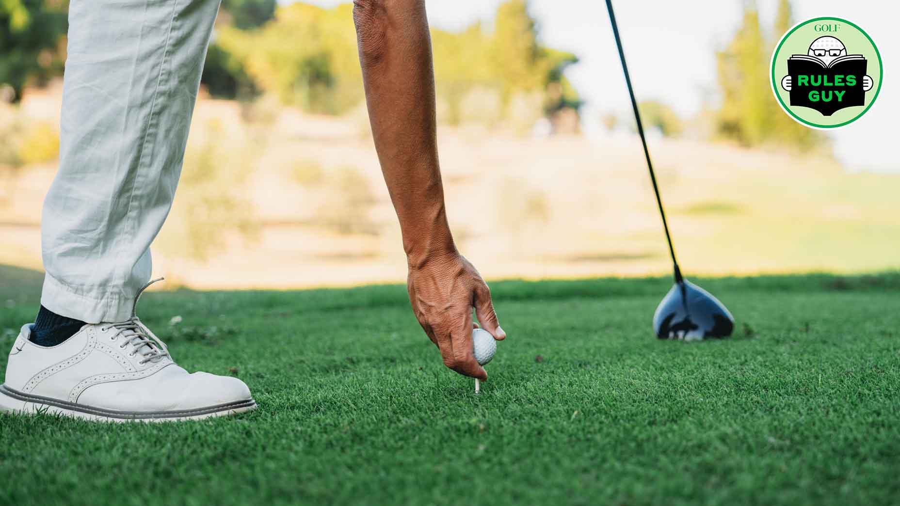 A golfer is preparing for strike. Close up detail of his hand holding the ball.