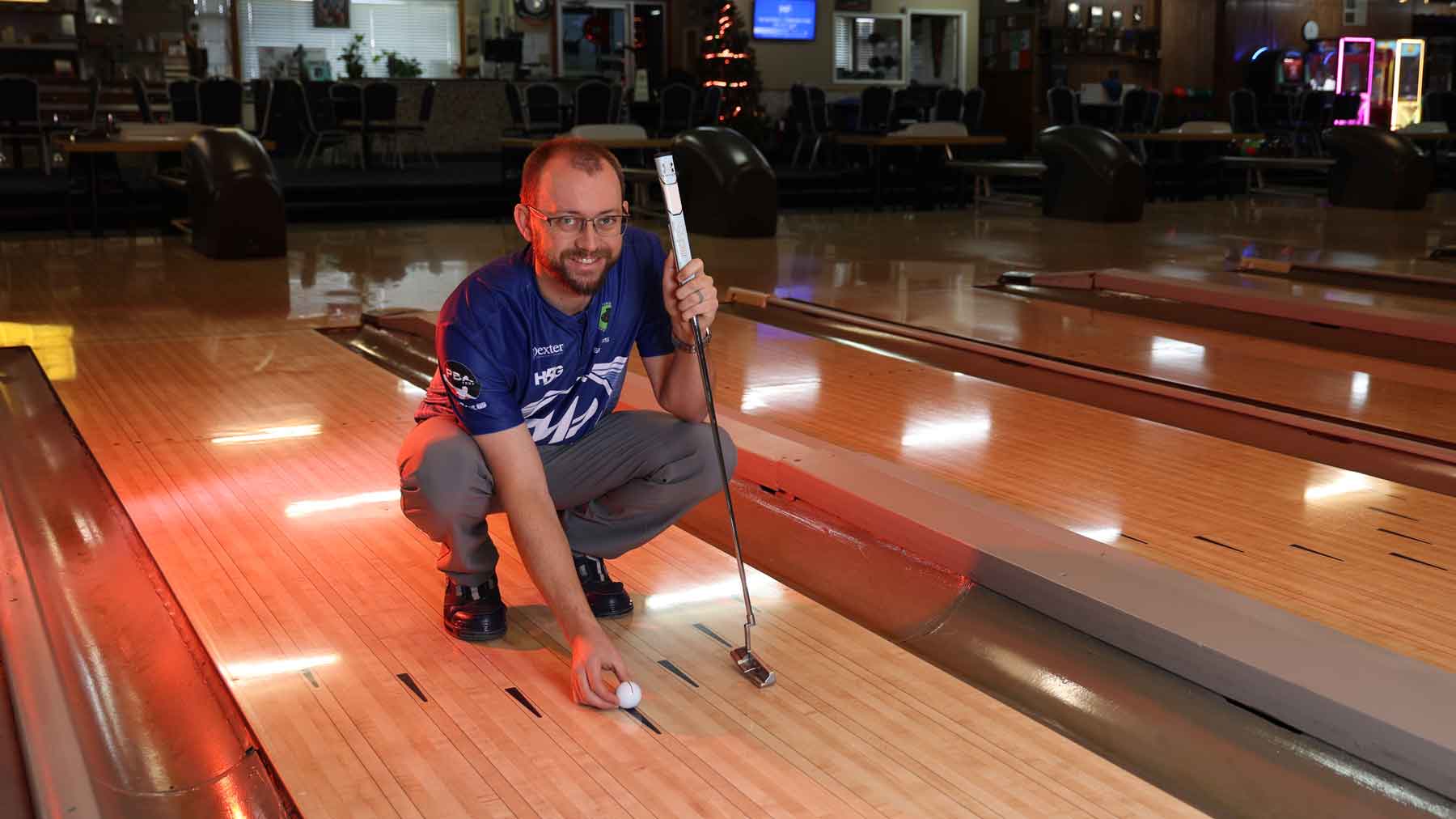 EJ Tackett lining up putt on bowling alley