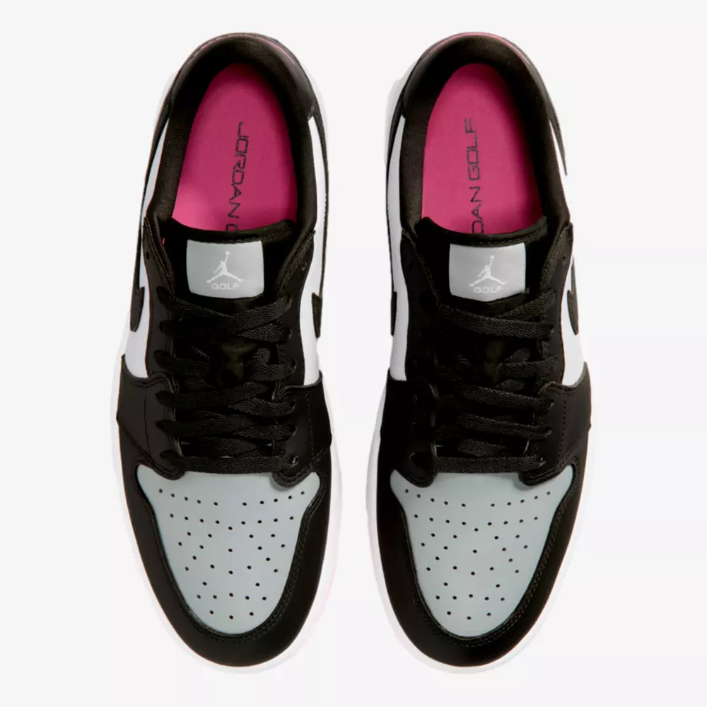 A pair of black and white sneakers with light gray perforated toe boxes and black laces. The pink and red insoles each feature the text JORDAN GOLF, making them stand out as some of the best Jordan golf shoes. The shoes are viewed from above.