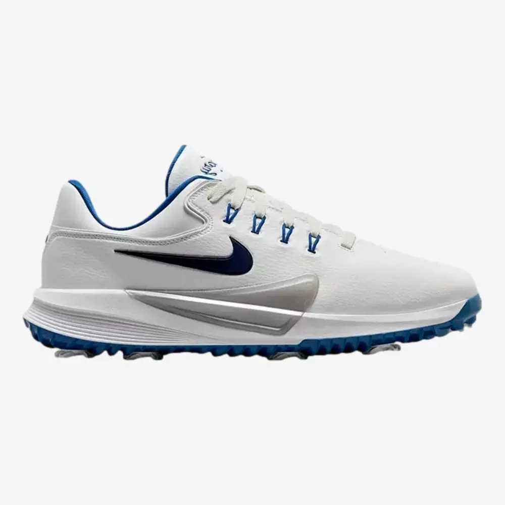 A white Nike athletic shoe with blue and silver accents, featuring a navy blue Nike swoosh logo, blue details on the sole and lace holes, and a textured blue sole designed for traction—an ideal pick among the best golf shoes 2026.
