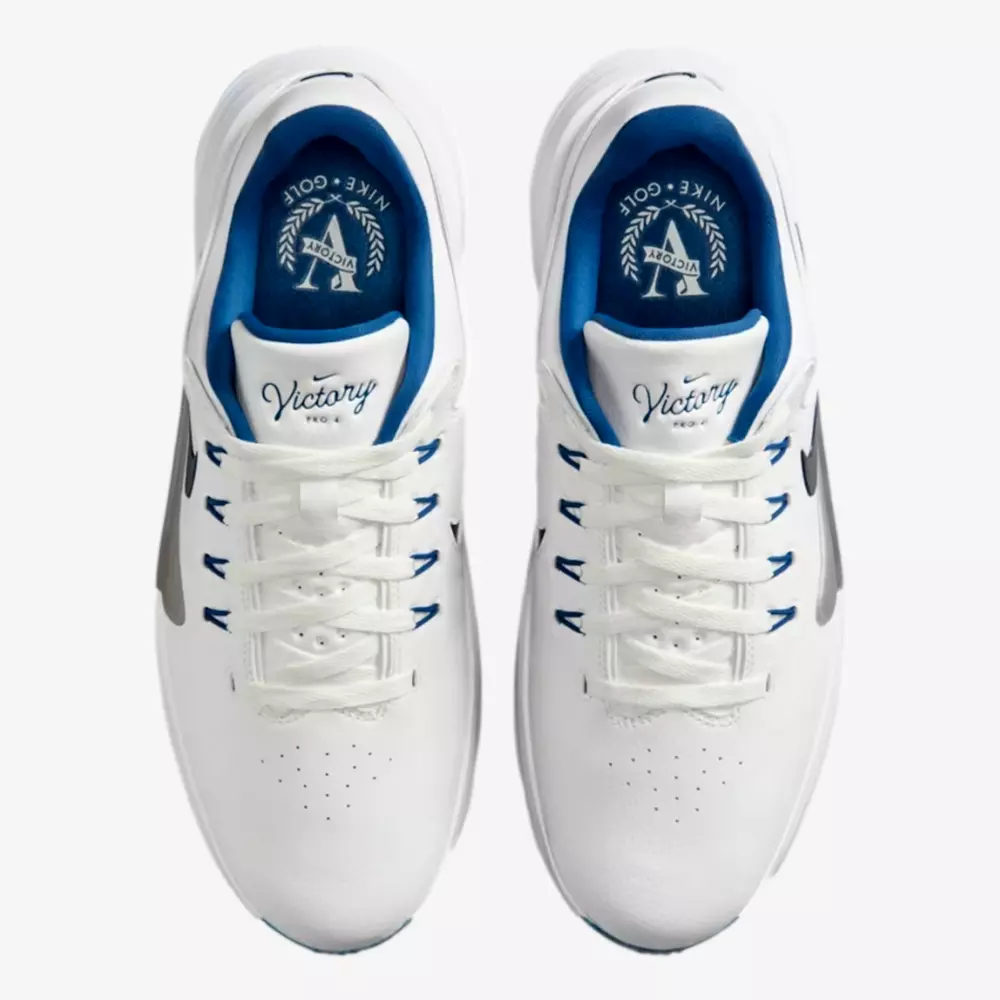 Top view of a pair of white athletic shoes with blue inner lining, white laces, and Victory text on the insoles. Featuring the Nike logo, these could be among the best golf shoes 2026 has to offer.