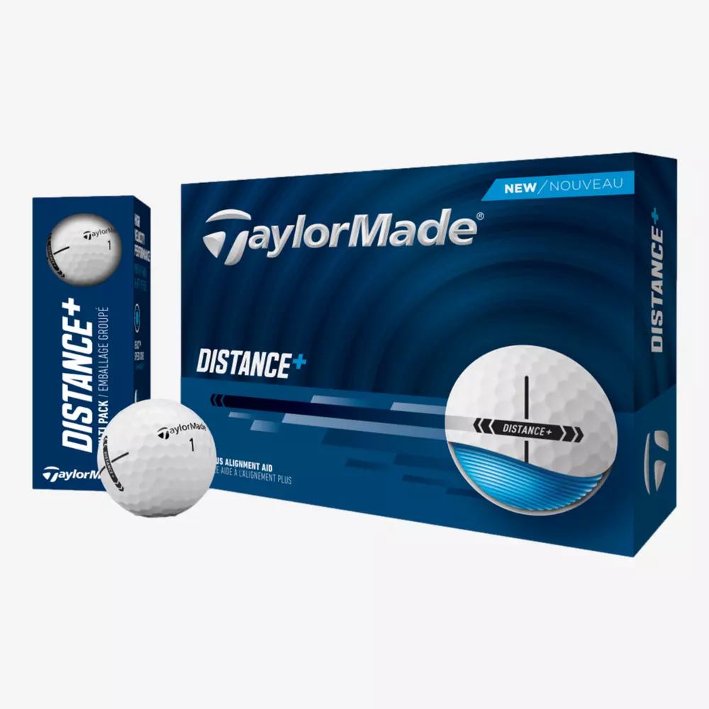 A box of TaylorMade Distance+ golf balls is shown with a smaller pack beside it and two balls in front—one featuring a black alignment aid line. The blue and white packaging pairs well with the best golf shoes 2026 for your next round.