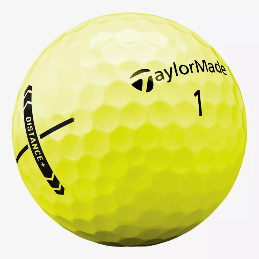 A close-up of a yellow TaylorMade golf ball with dimpled texture, the number 1, and black graphics including the word DISTANCE+ and the TaylorMade logo—perfect for pairing with the best golf shoes 2026 on your next round.