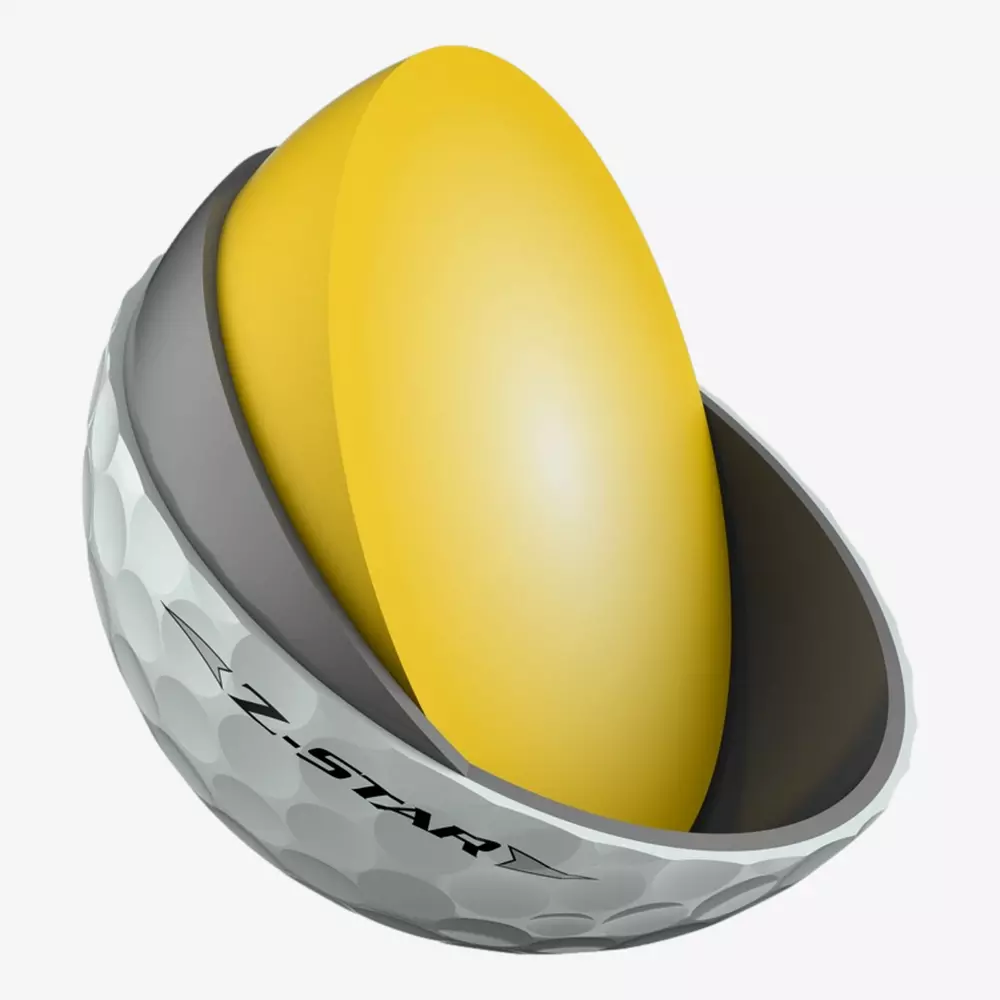 A cross-section of a Z-Star golf ball, showing the white dimpled outer layer, a dark inner layer, and a large yellow core—perfect for those aiming to match their skills and gear with the best golf shoes 2026 has to offer.