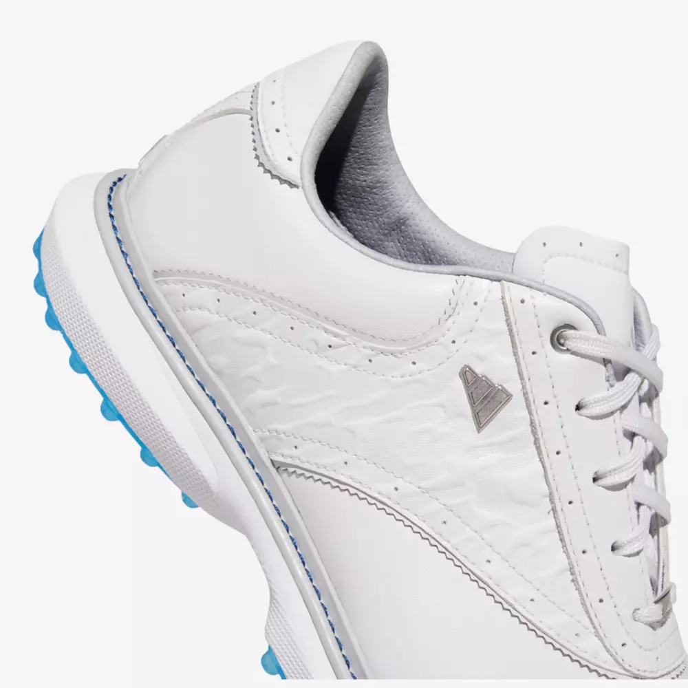 Close-up of a white sneaker with light blue accents, textured side panel, white laces, and a silver triangular logo on the side—styled like the best Jordan golf shoes—shown on a plain background.