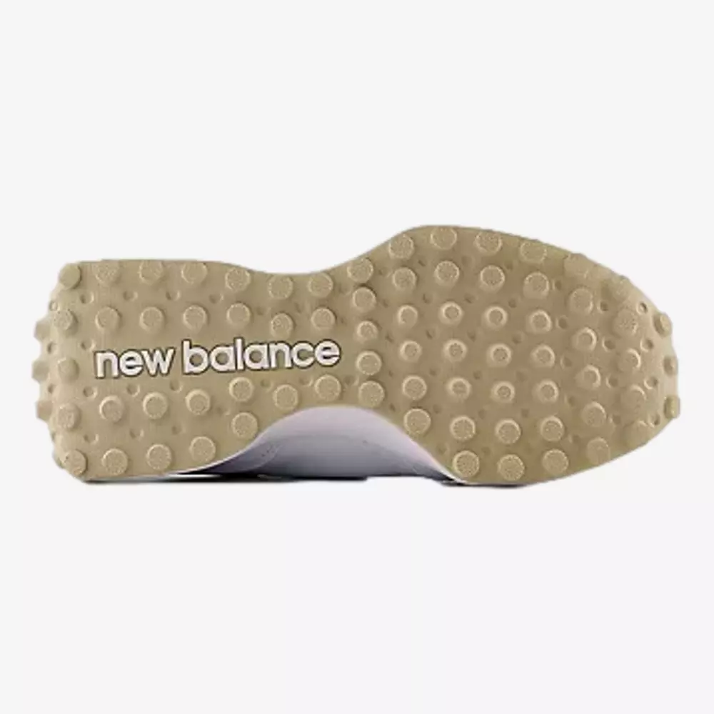 The sole of a New Balance shoe, beige in color with circular grip patterns and the new balance logo in white text across the bottom&mdash;an inspired design for those seeking the best golf shoes 2026.