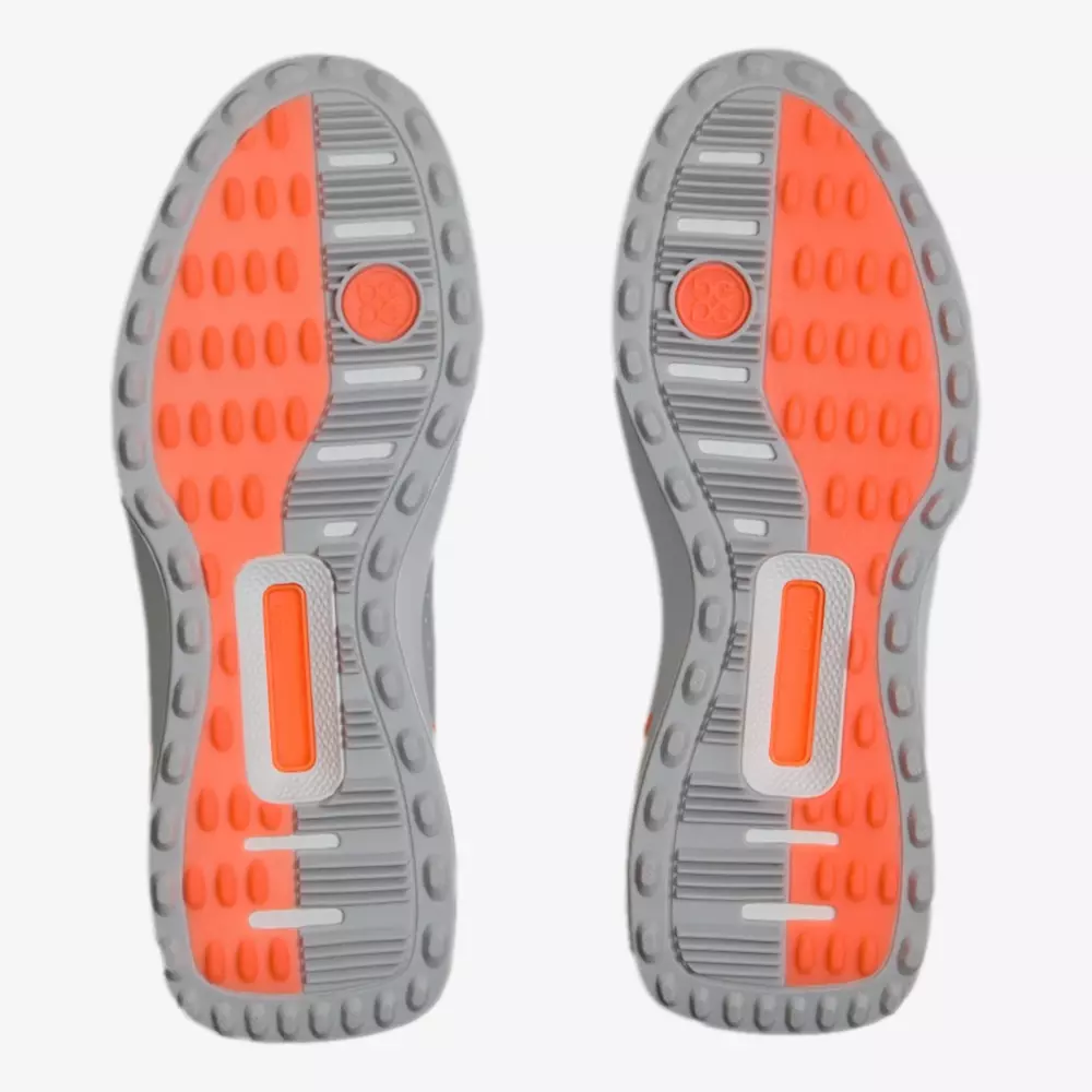 A pair of athletic shoe soles with a gray and bright orange color pattern, reminiscent of the best Jordan golf shoes, featuring circular and rectangular treads, plus both textured and smooth areas for optimal grip.