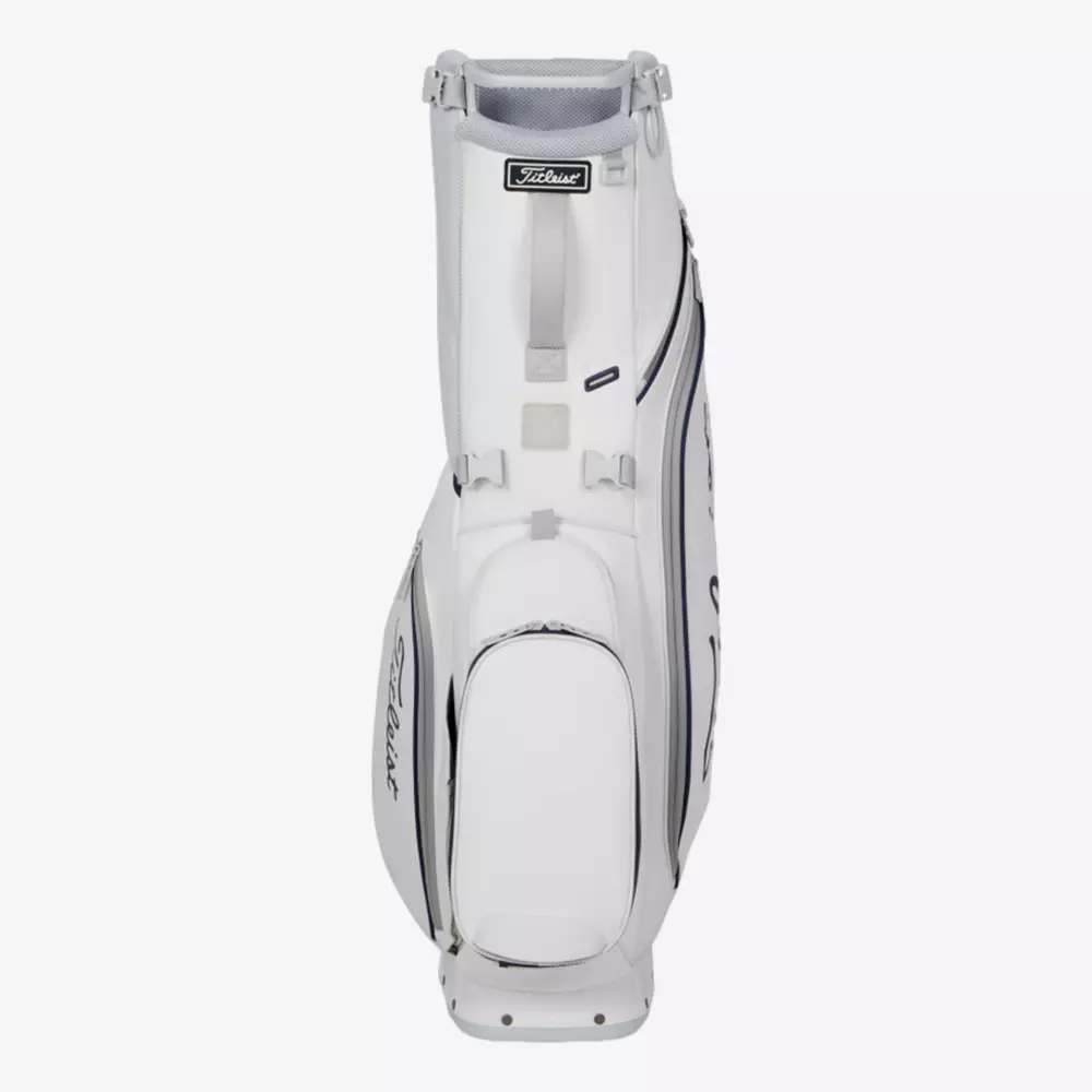 A white Titleist golf bag with multiple zippered compartments and handles, standing upright on a plain light background. The Titleist logo is visible on the side and near the top—an excellent choice among the best golf bags 2026.