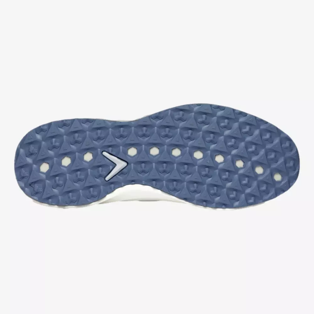 The image shows the sole of a shoe, possibly one of the best golf shoes 2026, with a blue diamond-patterned tread and circular cutouts. A white chevron-shaped detail appears near the center against a plain, light-colored background.