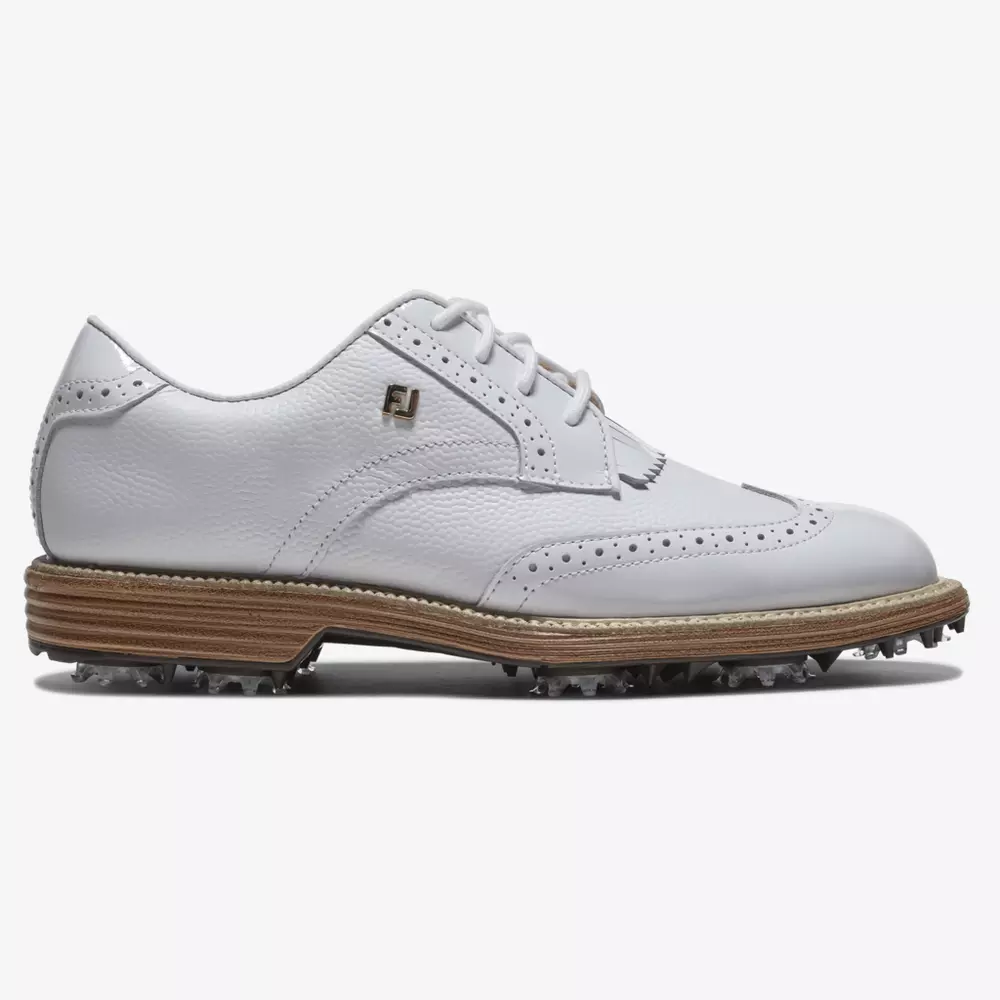 A white leather golf shoe with wingtip design, perforated detailing, white laces, tan midsole, and spiked sole. An FJ logo is visible near the ankle&mdash;crafted for performance among the best golf shoes 2026. The background is plain white.