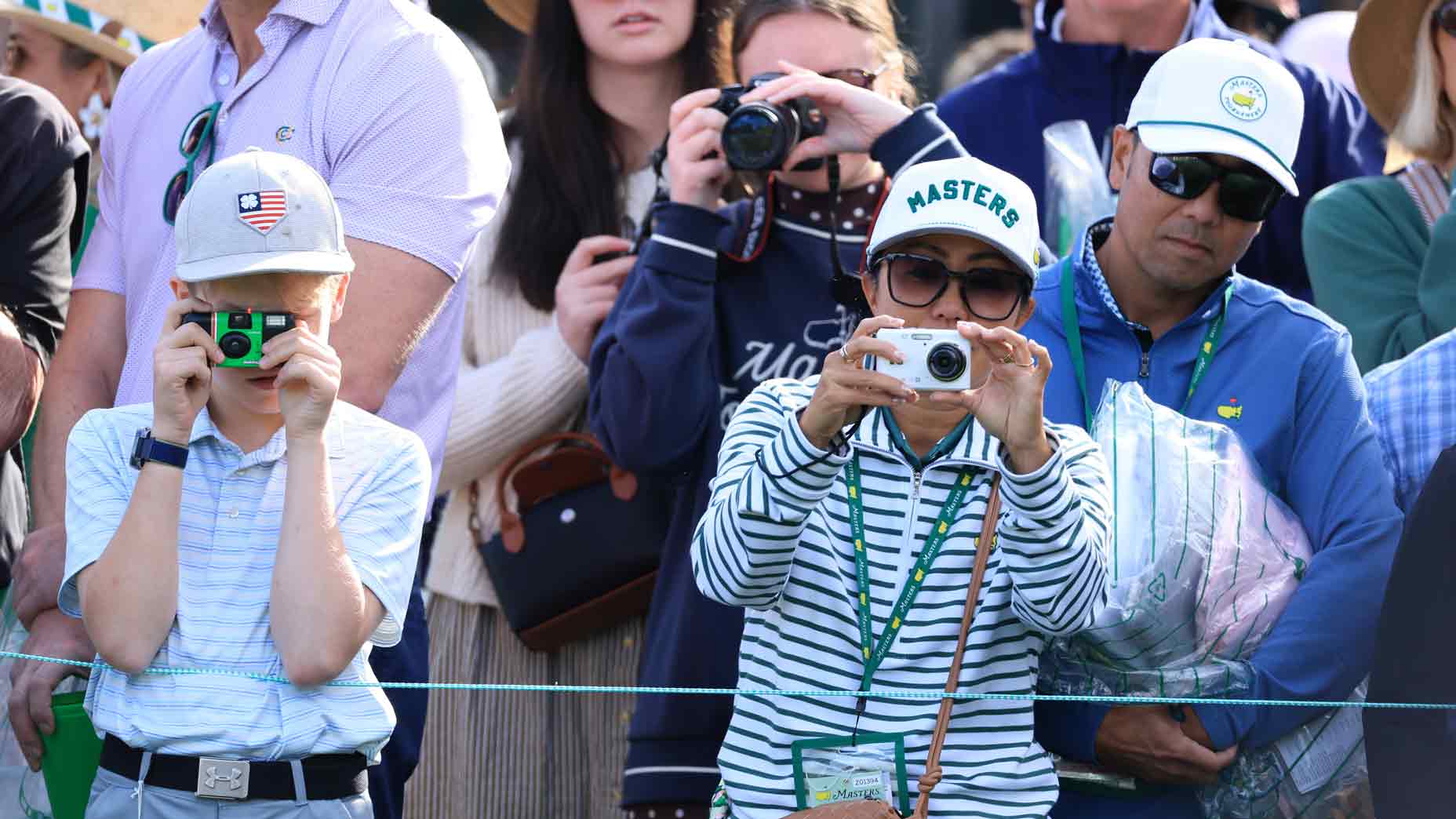 2026 Masters TV Schedule: A crowd of Masters fans stands close together, many holding cameras, taking photos.