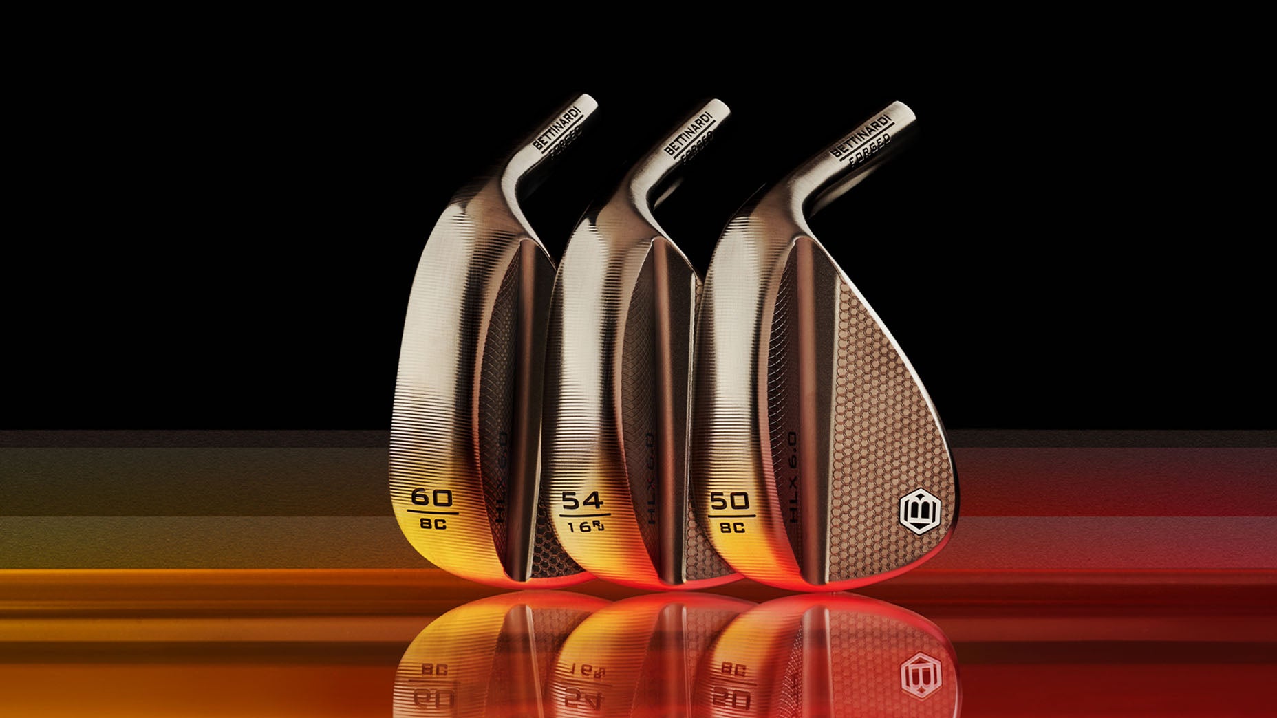 Three shiny, metallic golf wedges with engraved numbers and text are displayed upright in a row against a black background with warm orange reflections on the surface below them.