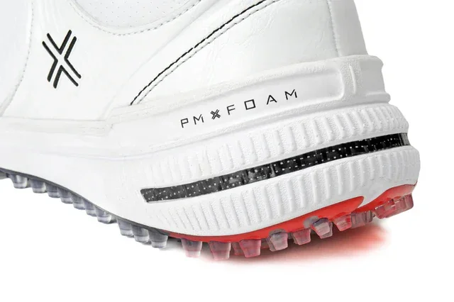 Close-up of the heel of a white athletic shoe with PMX FOAM printed on the side, black detailing, and a red and translucent spiked sole designed for traction—an advanced design seen in the best golf shoes 2026.