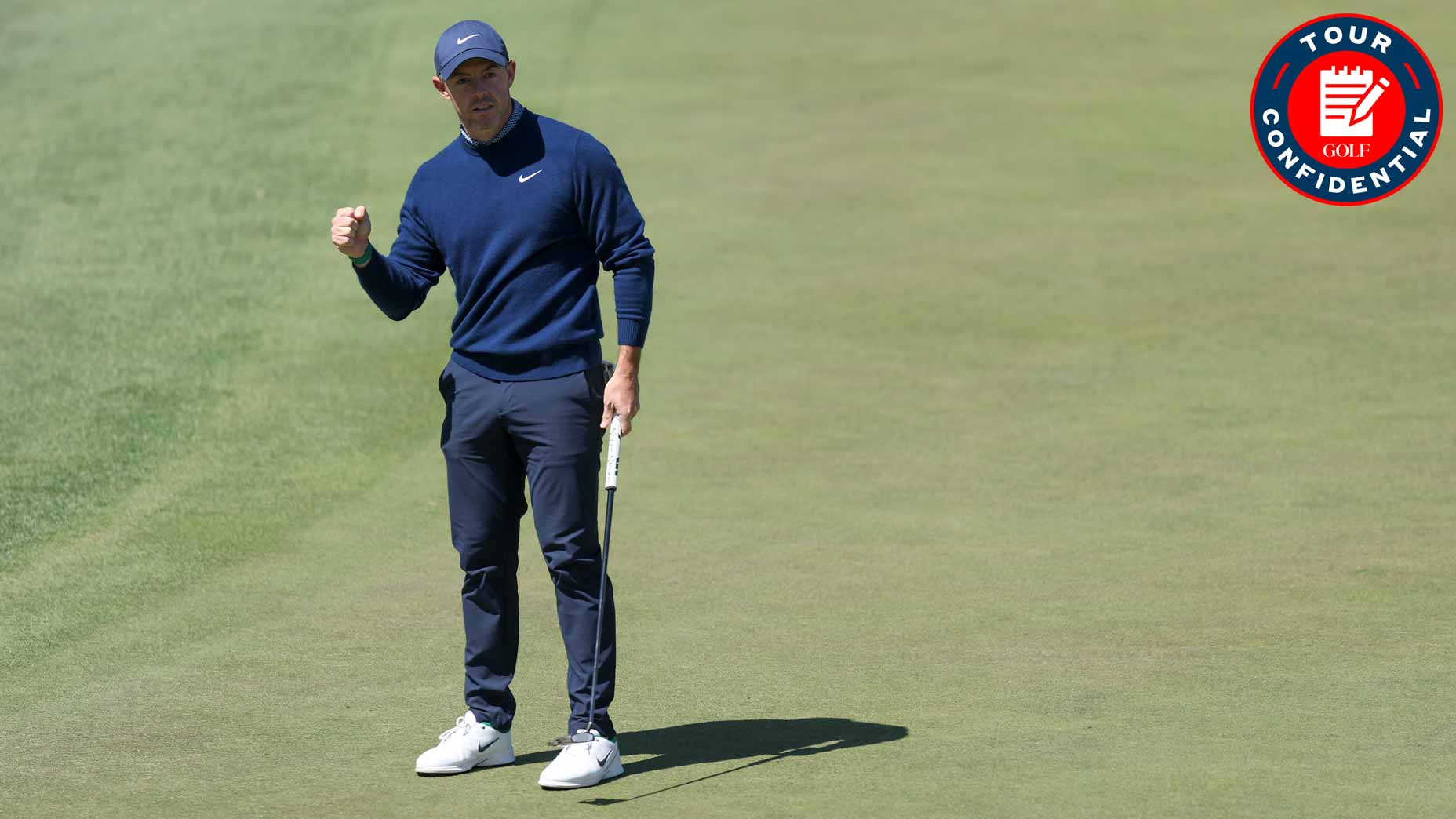 A golfer wearing a navy sweater, dark pants, and a cap celebrates with a fist pump while standing on a golf green, holding a putter. A red Tour Confidential logo appears in the top right corner.