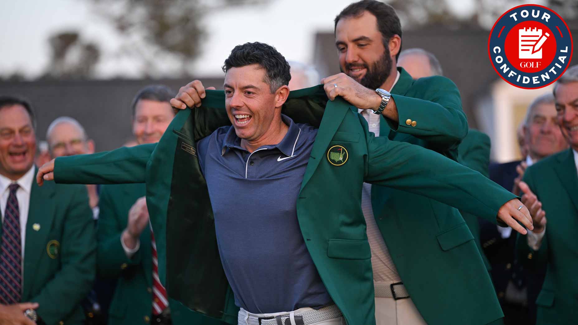 A smiling golfer is helped into a green jacket by another man during an award ceremony, surrounded by applauding people in suits. A Tour Confidential logo appears in the top right corner.