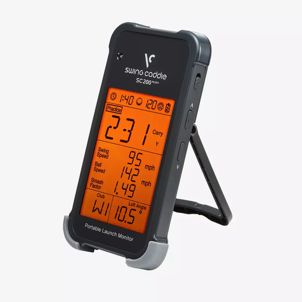A black Swing Caddie SC200 Plus portable launch monitor with an orange display showing golf stats like carry distance and swing speed, standing on its built-in stand—one of the best golf deals for $100 or less.