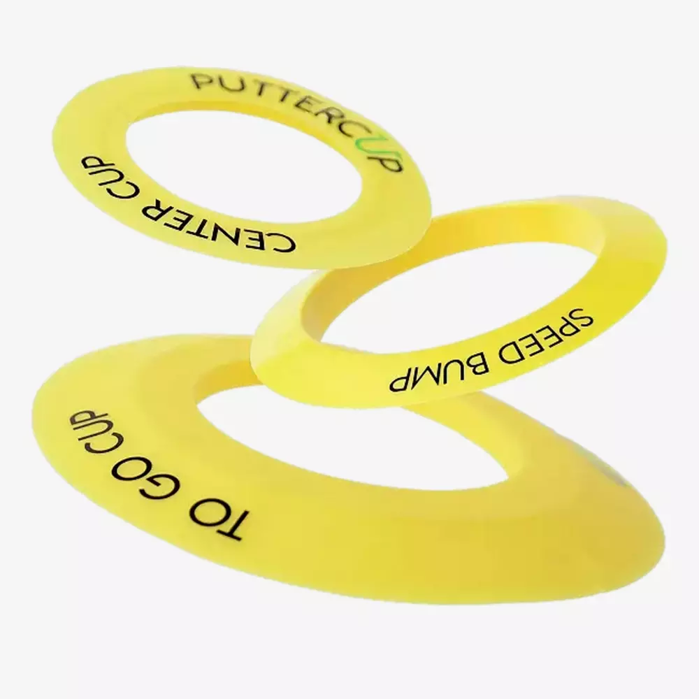 Three yellow plastic rings labeled PUTTER CUP, SPEED BUMP, and TO GO CUP are displayed against a white background, appearing as if they are floating or stacked diagonally—perfect for those seeking the best deals under $50.