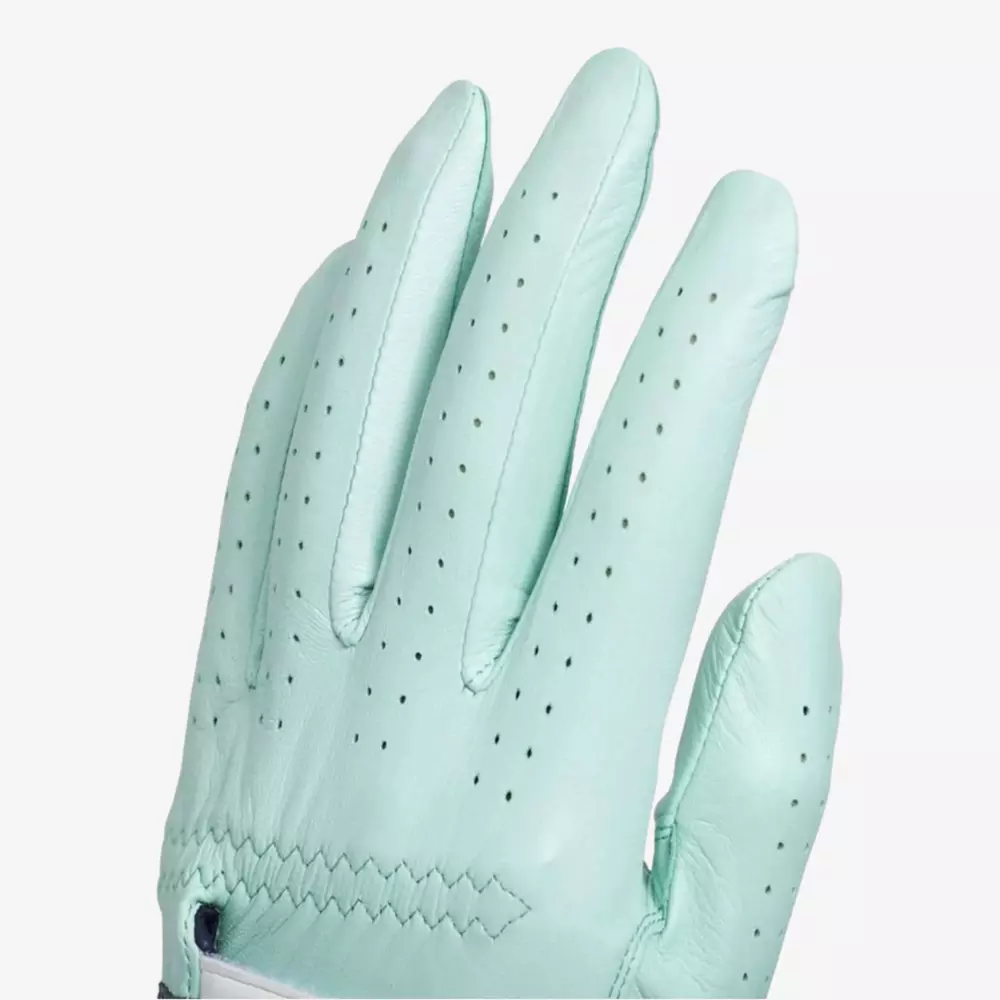 A close-up of a light turquoise leather glove, showing perforations on the fingers for ventilation and detailed stitching near the wrist—an essential accessory for those seeking the best golf bags 2026. The glove is worn on a left hand against a plain white background.